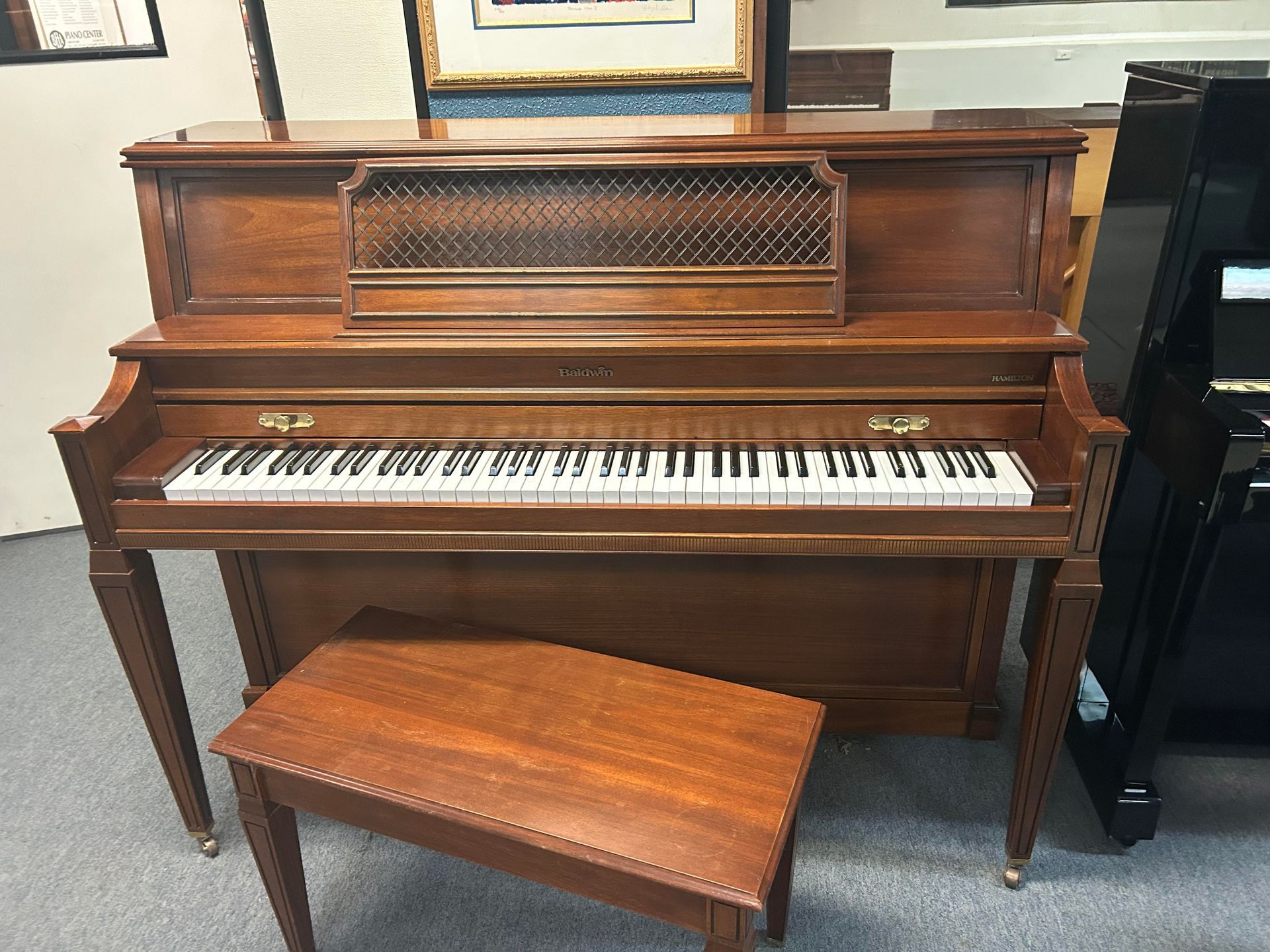 A piano with a bench next to it in a room.