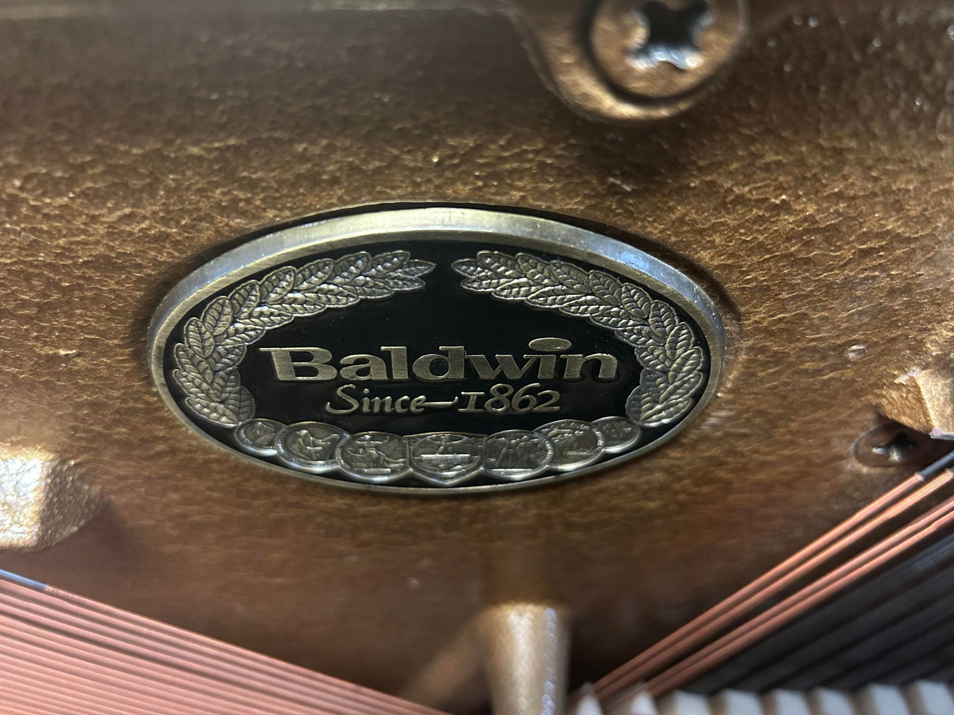 A close up of a baldwin label on a piano