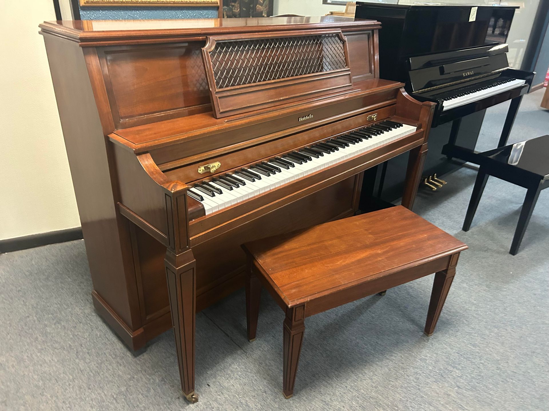A piano with a bench next to it in a room.