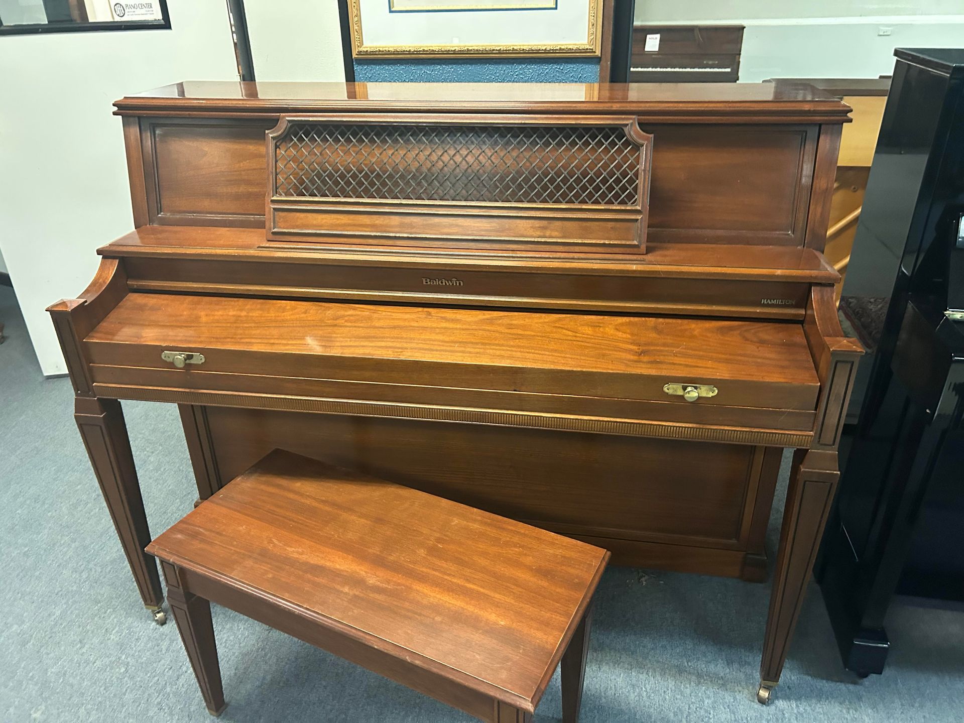 A piano with a bench next to it in a room.