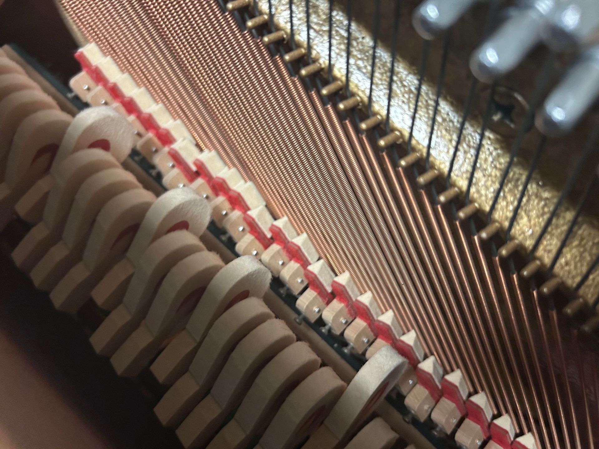 A close up of the inside of an upright piano
