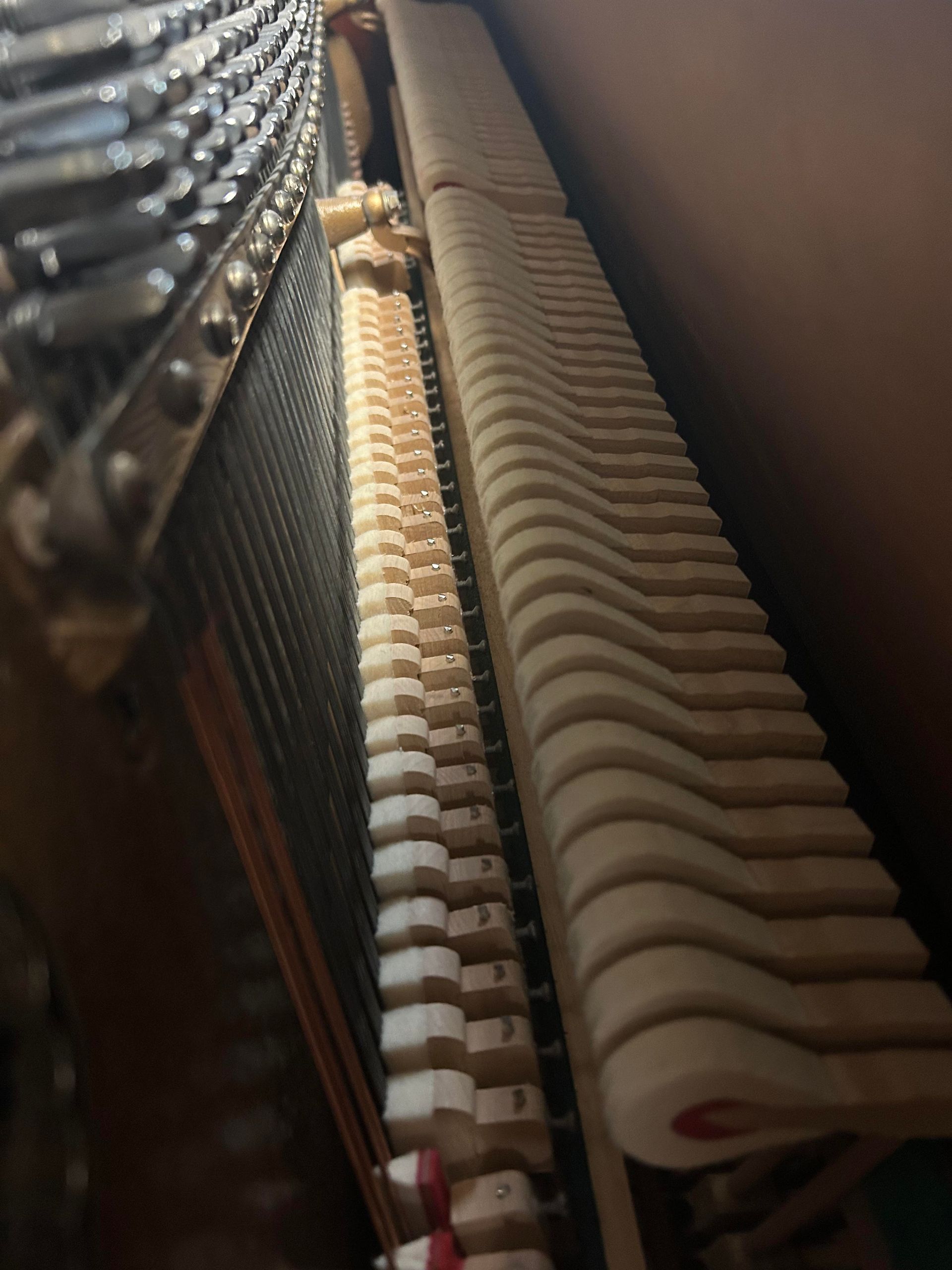A close up of the inside of an upright piano