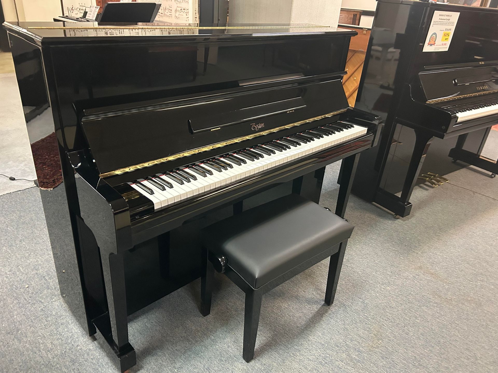 A black piano with a bench next to it in a room.