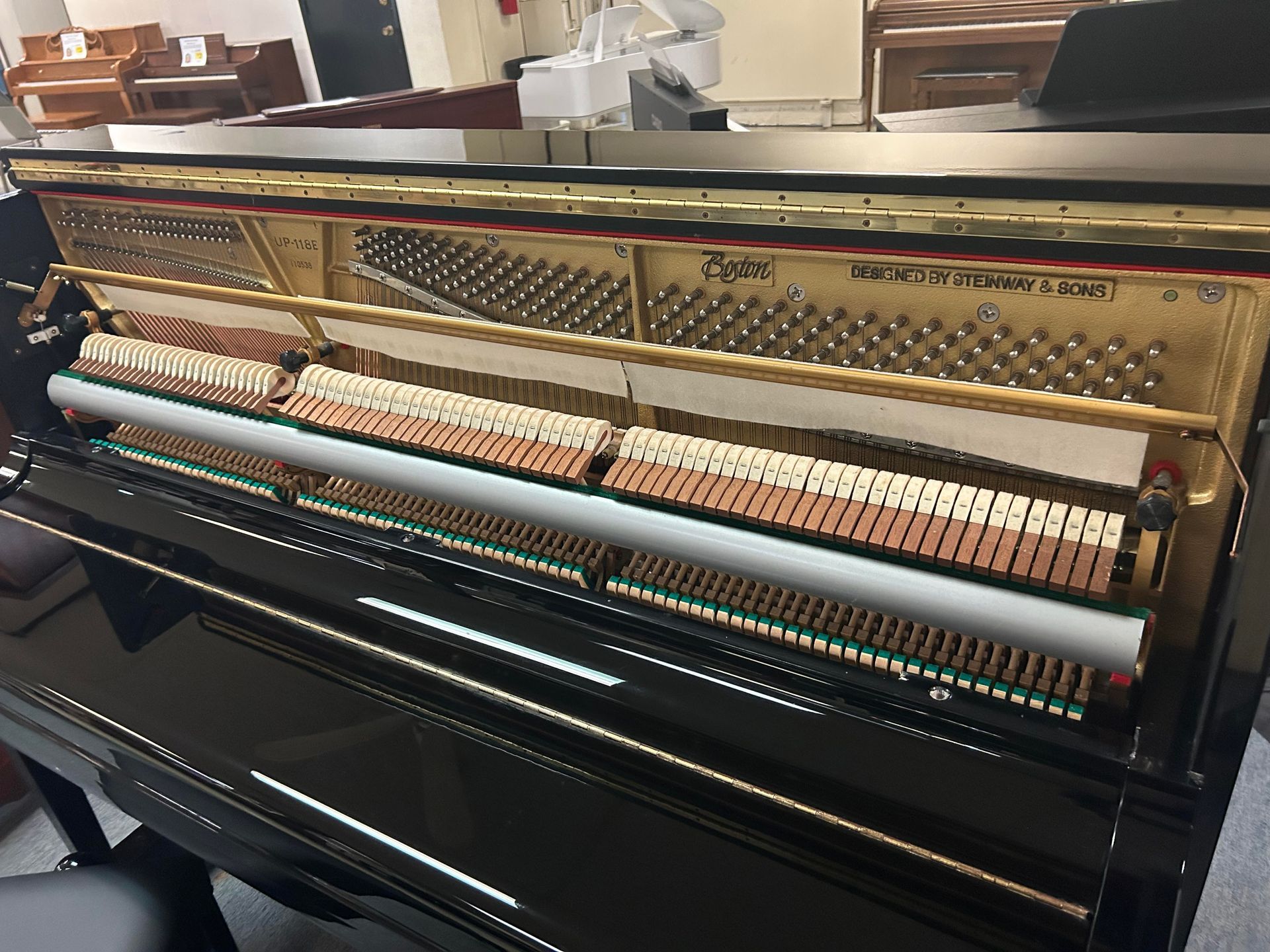 The inside of a black upright piano with the lid open.