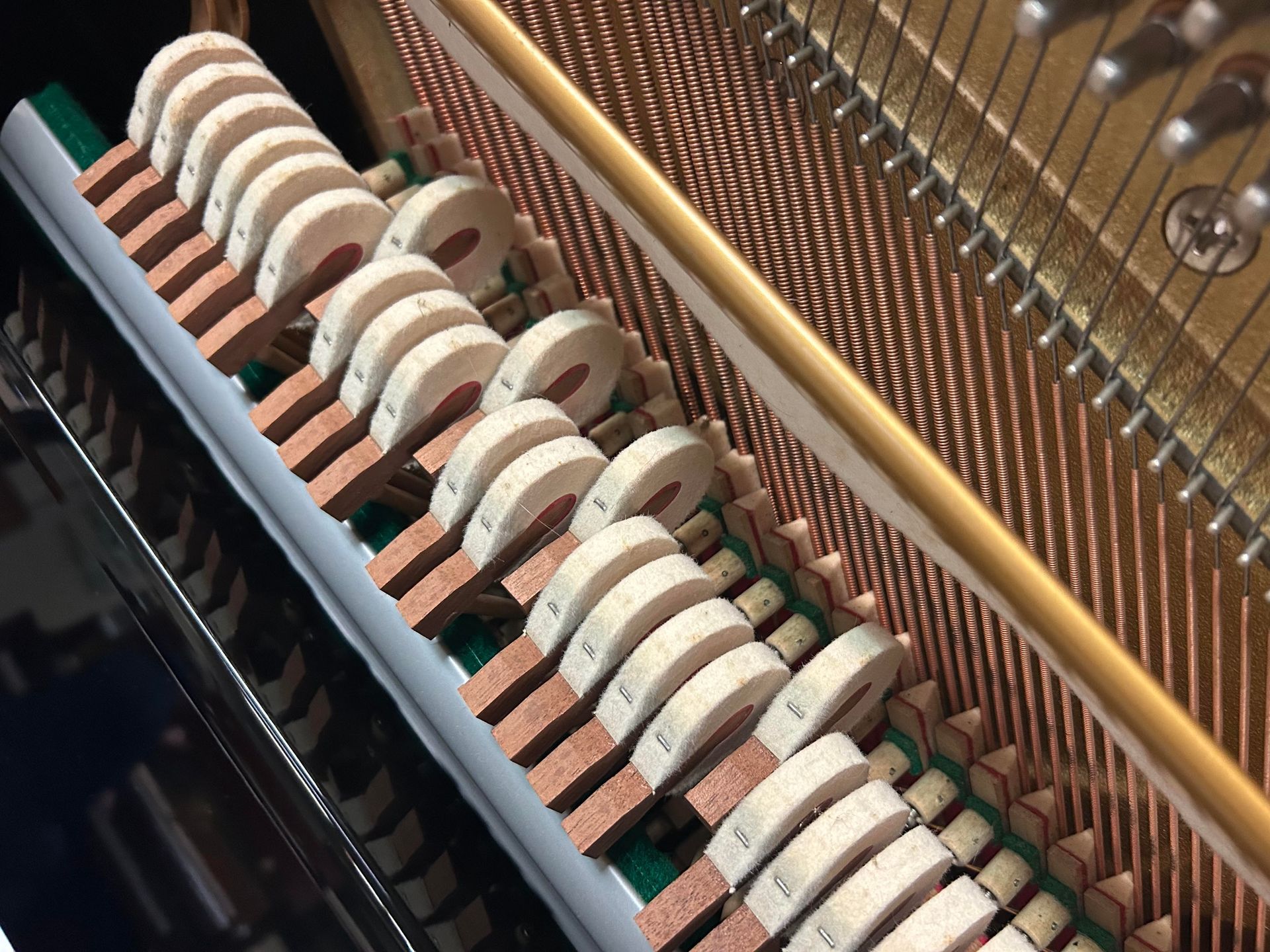 A close up of the inside of an upright piano