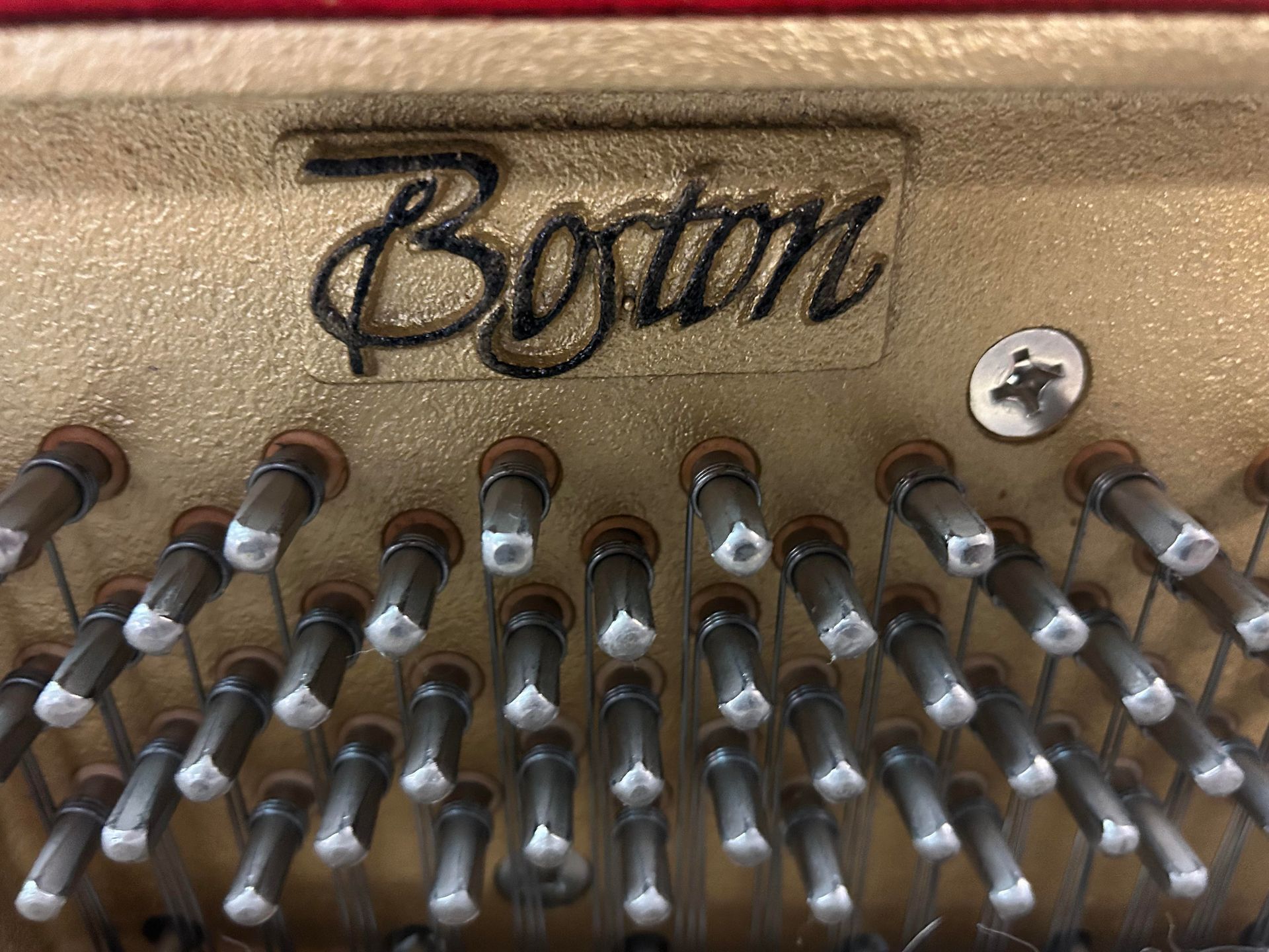 A close up of the inside of a boston piano