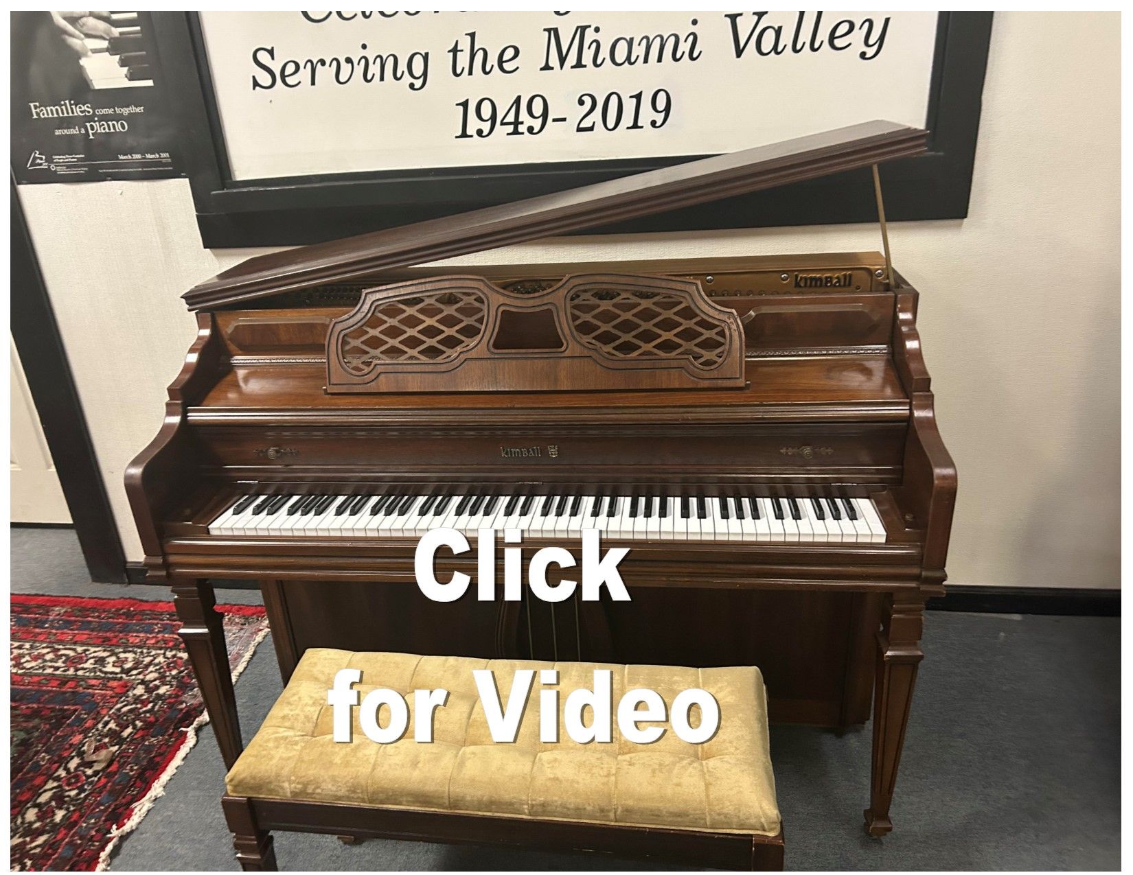 A piano is sitting in front of a sign that says serving the miami valley 1949-2019