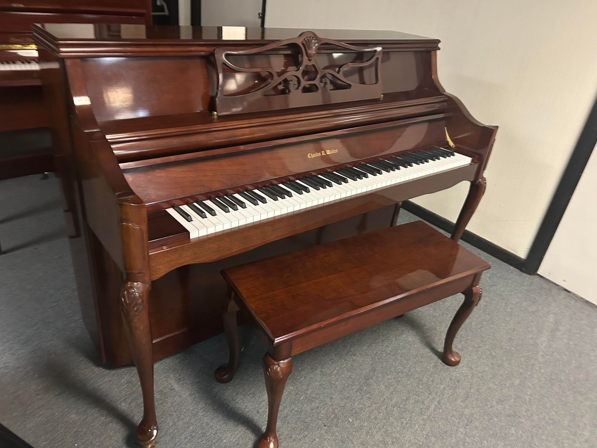 A piano with a bench next to it in a room