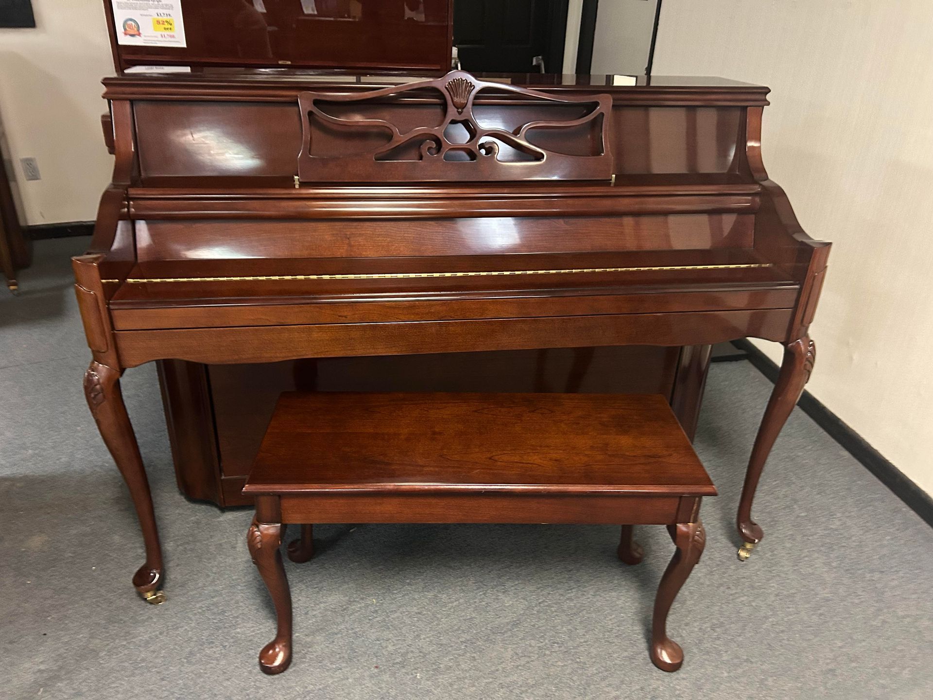 A piano with a bench next to it in a room.