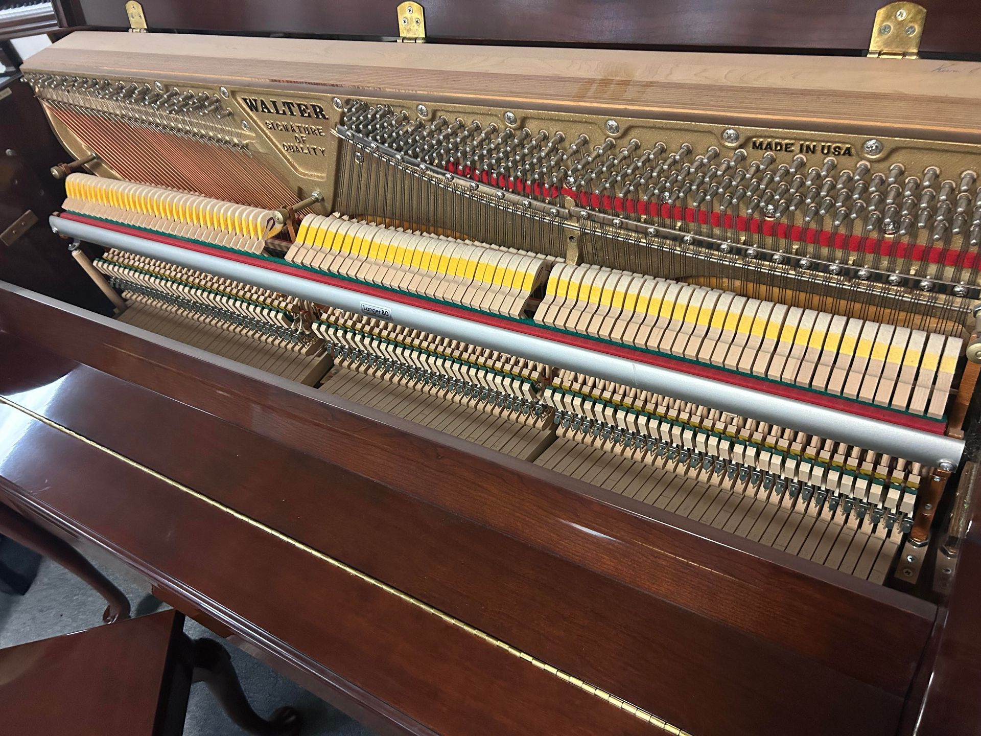 A close up of the inside of a piano showing the keys
