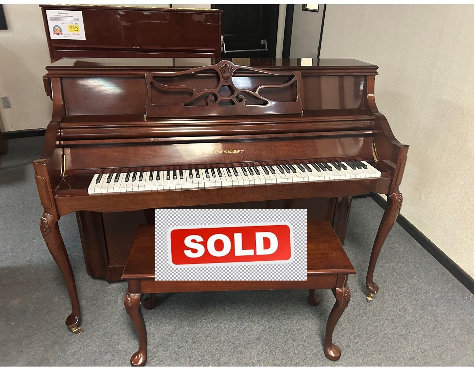 A piano is sitting in a room with the words click for video below it.