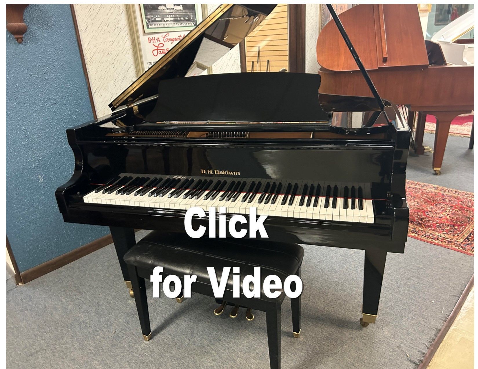 A black grand piano is sitting in a room next to a stool.