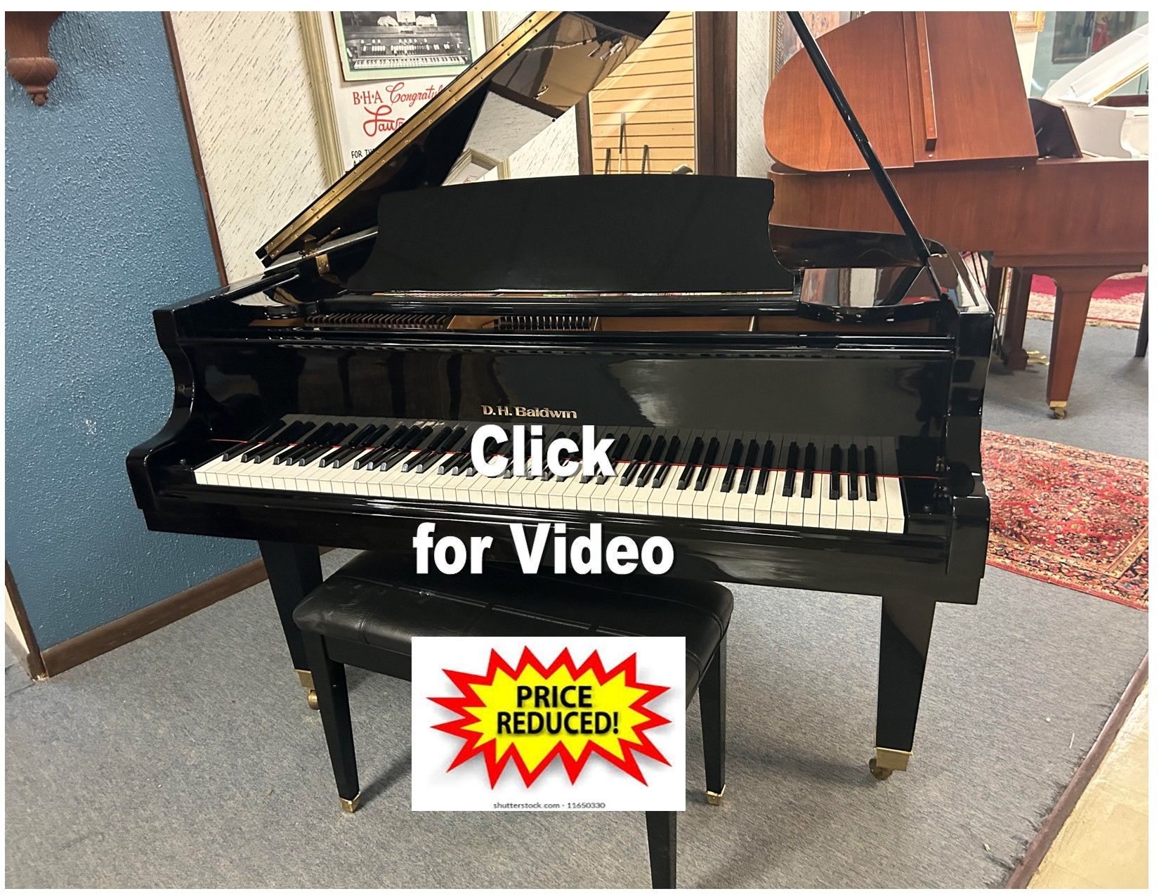 A black grand piano is sitting in a room next to a stool.