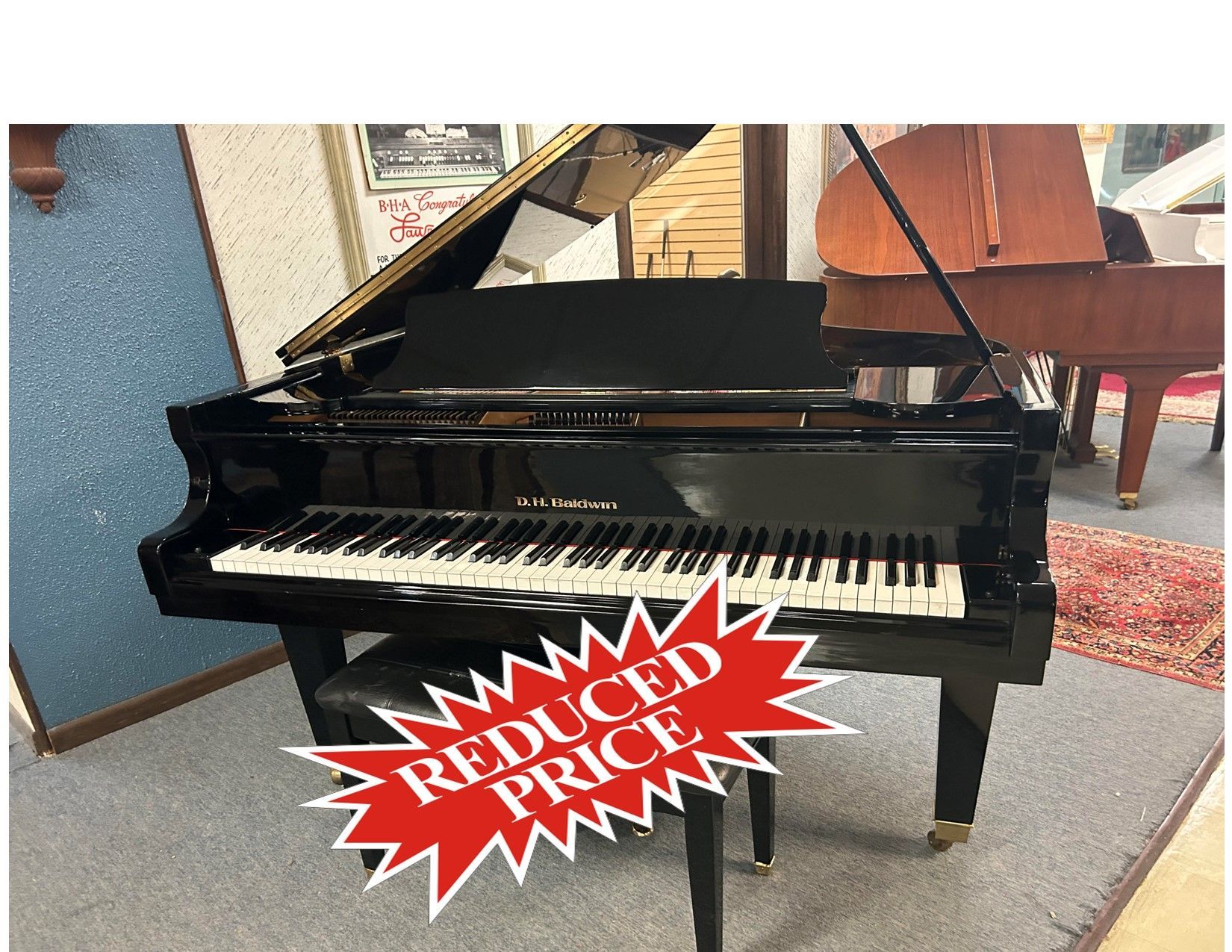 A black grand piano is sitting in a room next to a stool.