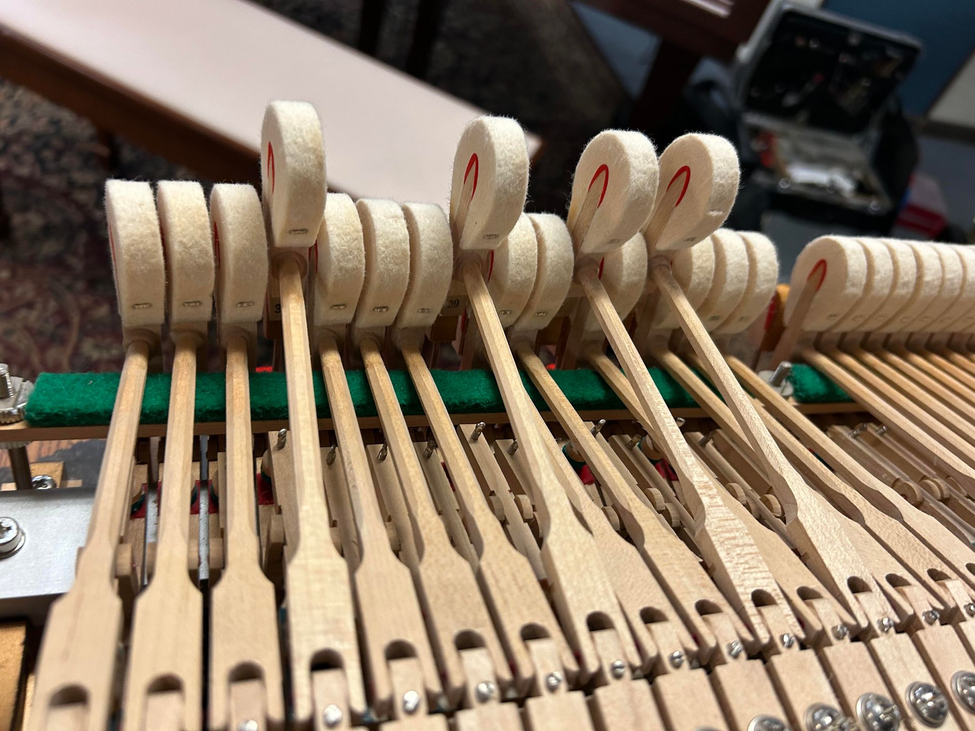 A close up of the inside of a piano showing the keys