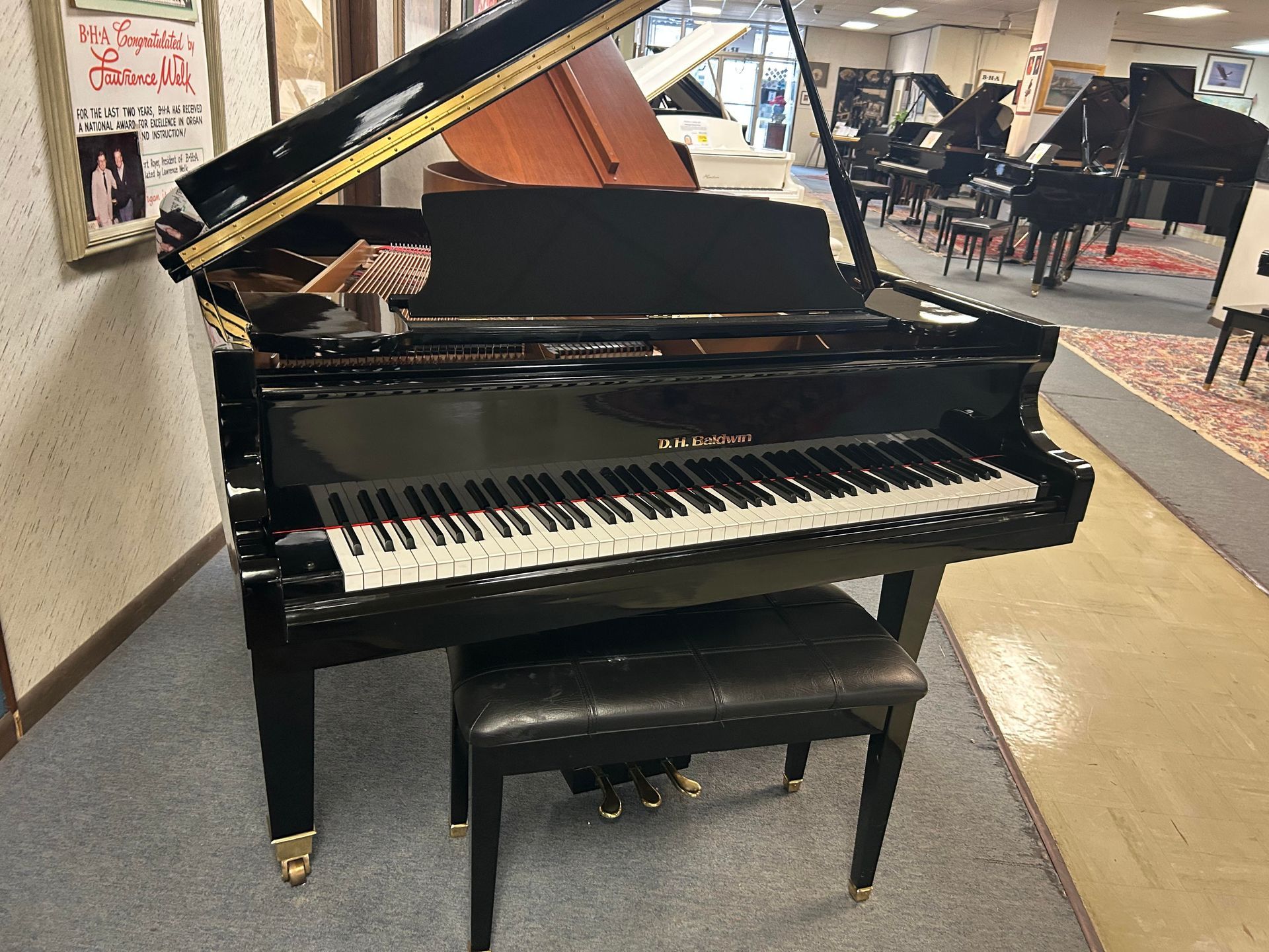 A black grand piano with a stool in a room