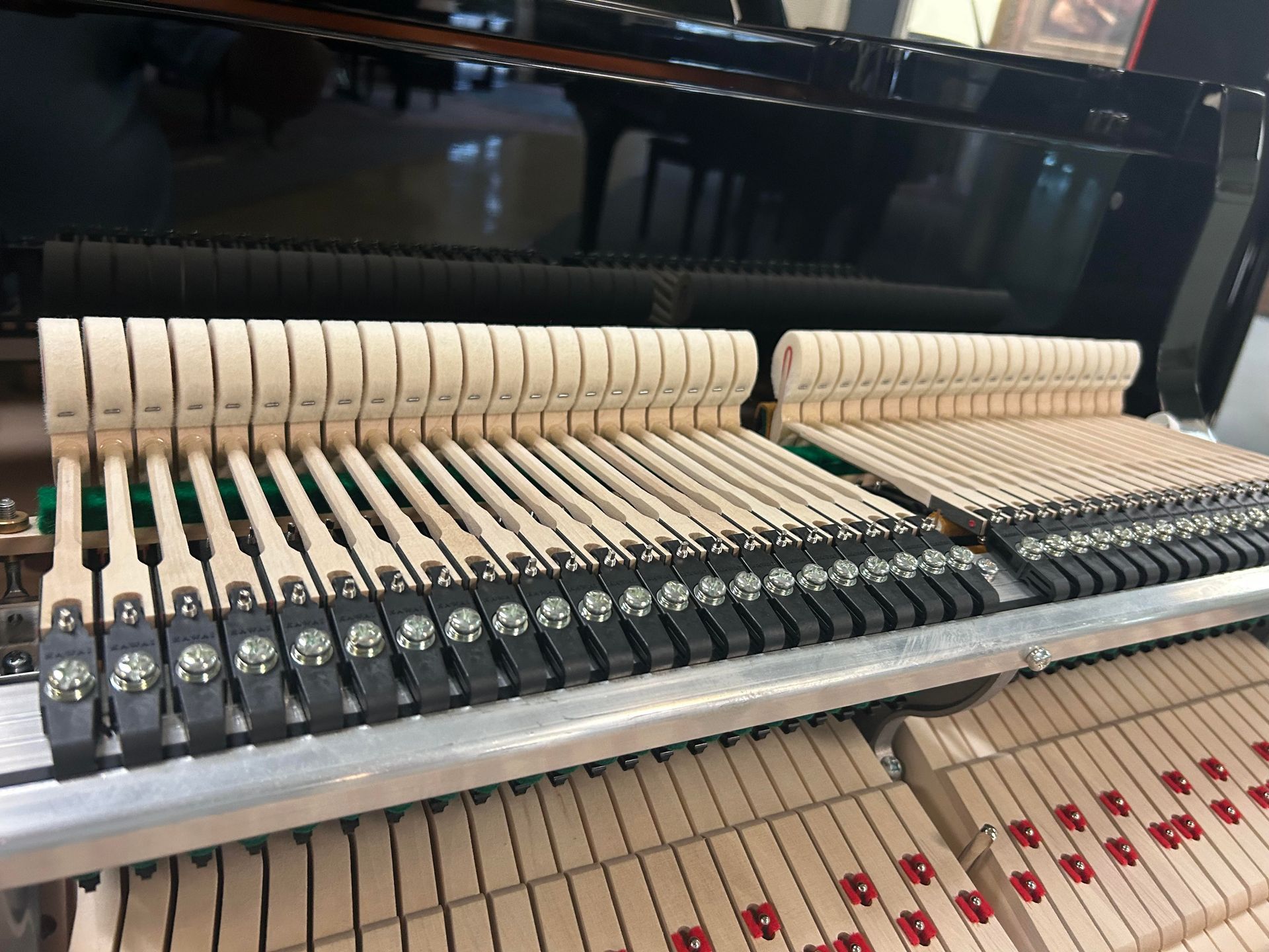 Inside of a piano, showing the hammers and keys.