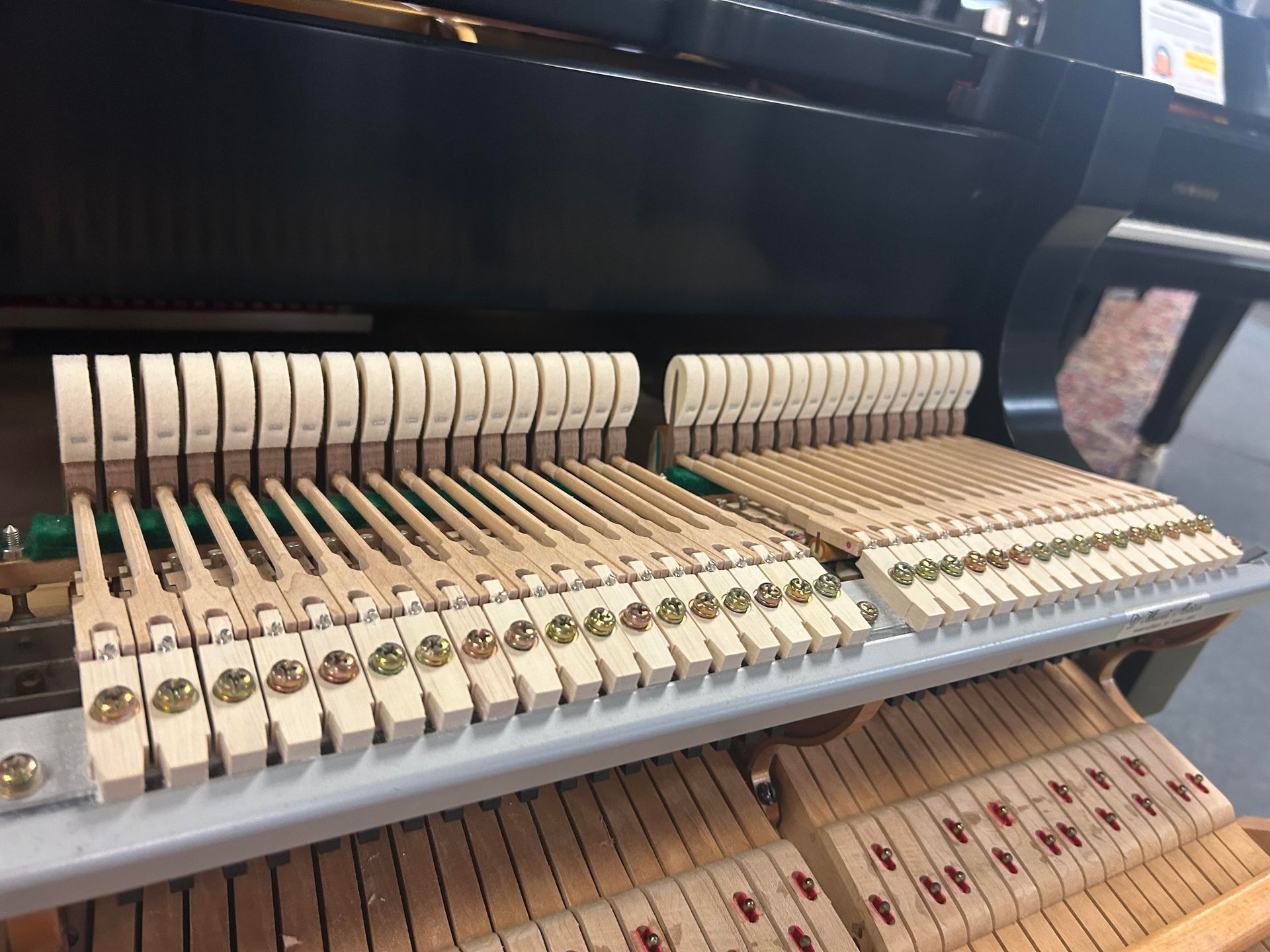 Piano hammers in a grand piano, visible from above, showing the wooden mechanism.
