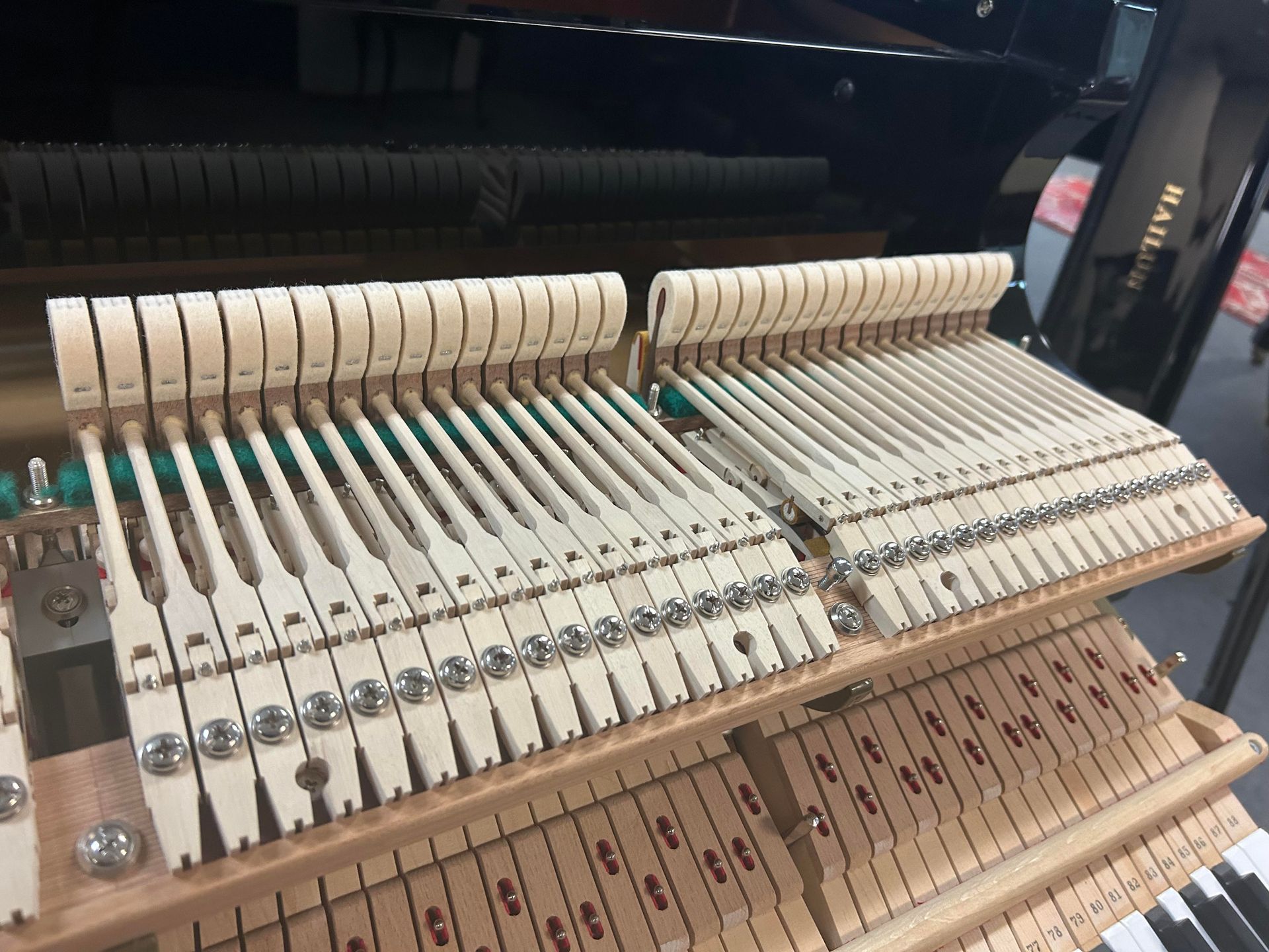 The inside of a piano with a lot of keys and hammers