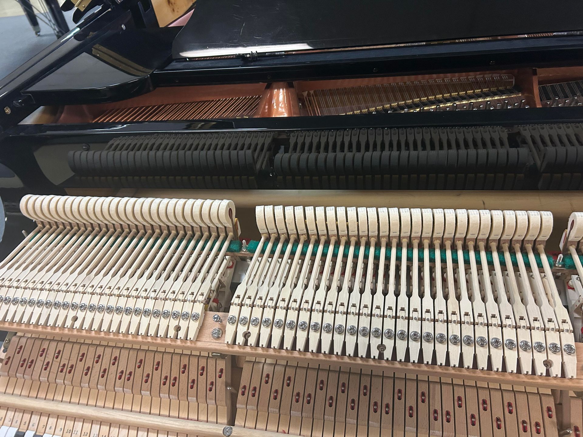 The inside of a piano showing the keys and hammers
