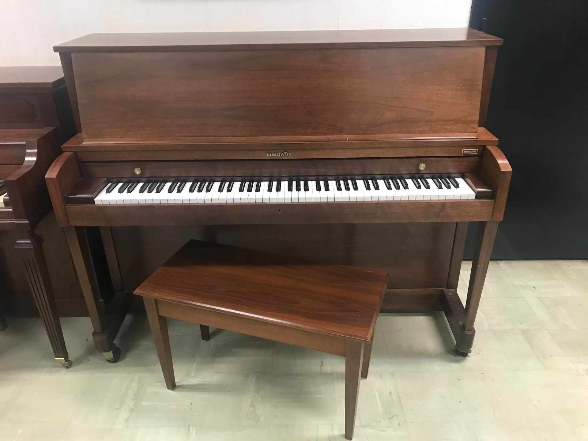 A piano with a bench next to it in a room.