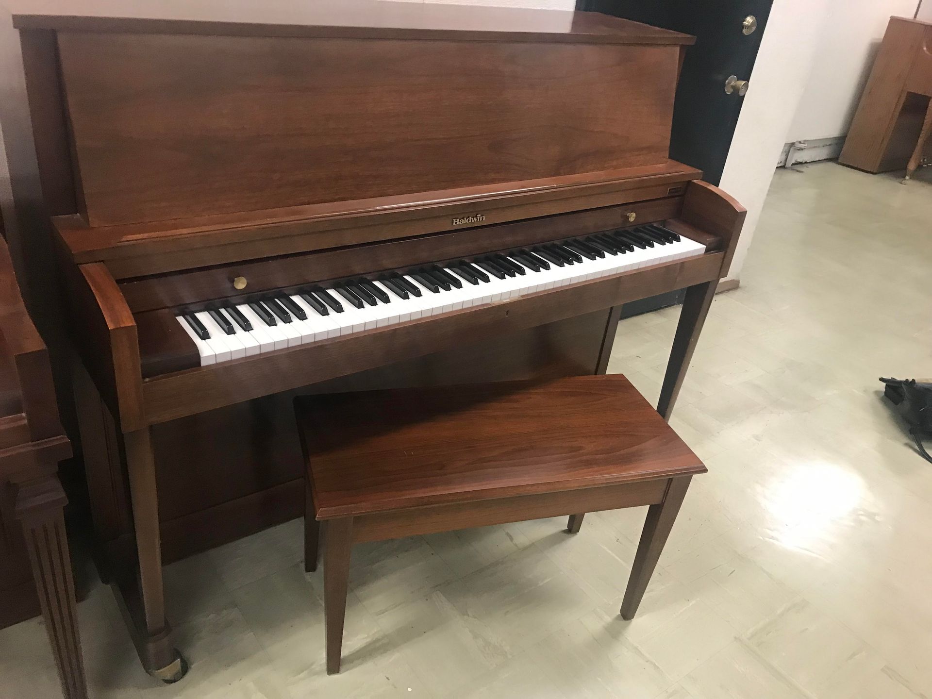 A piano with a bench next to it in a room.