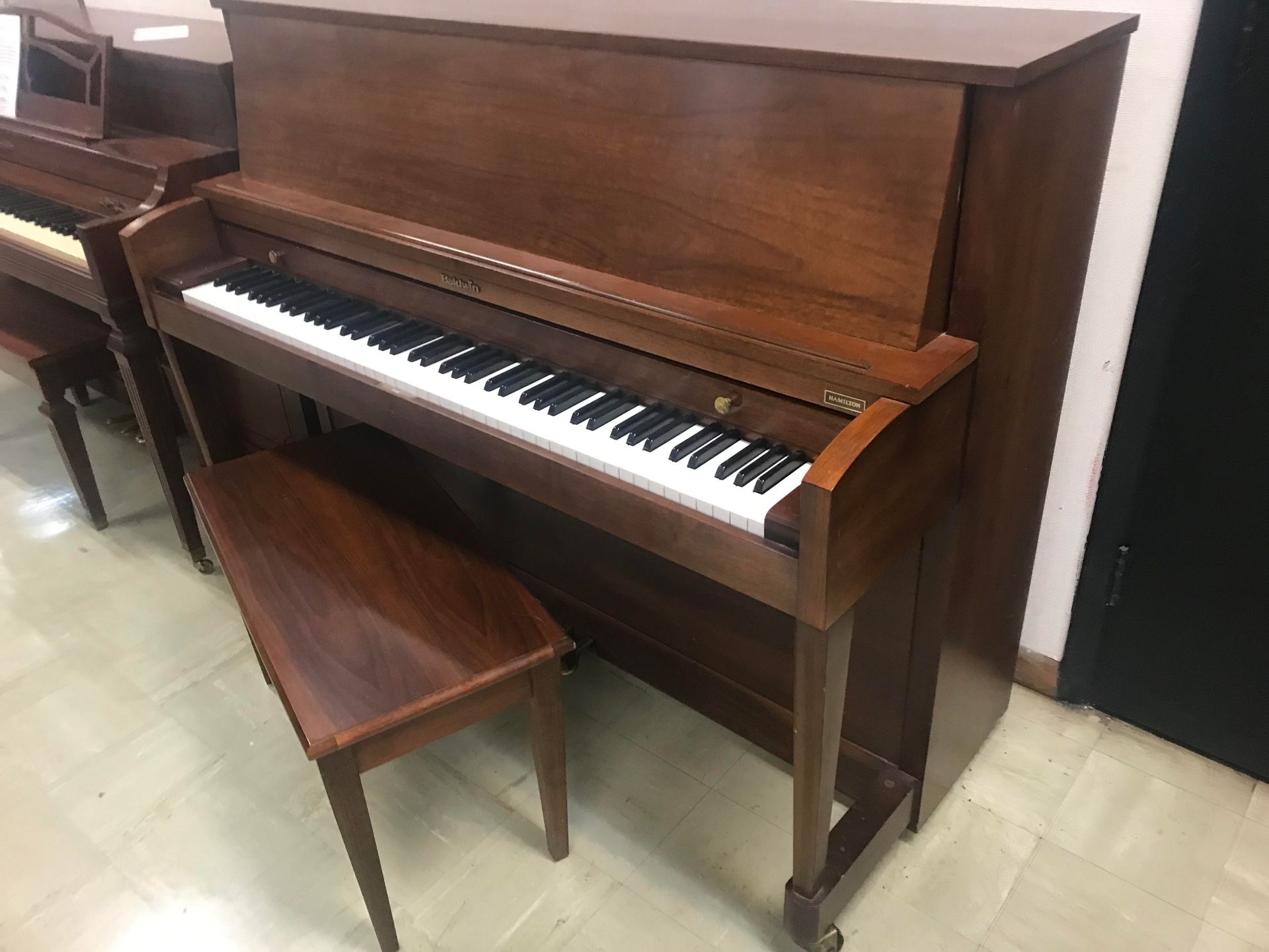 A piano with a bench next to it in a room.