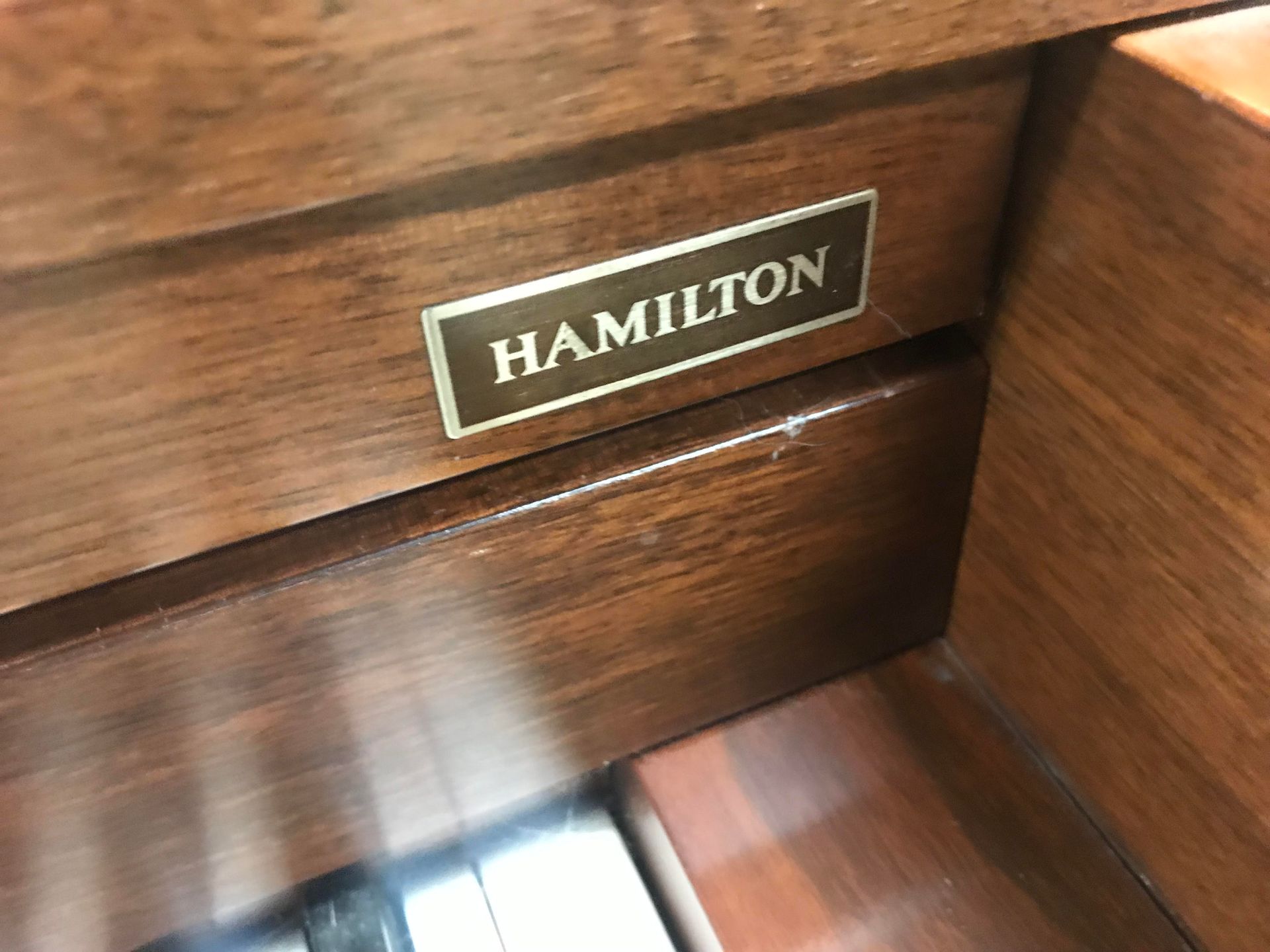 A close up of a hamilton label on a wooden cabinet
