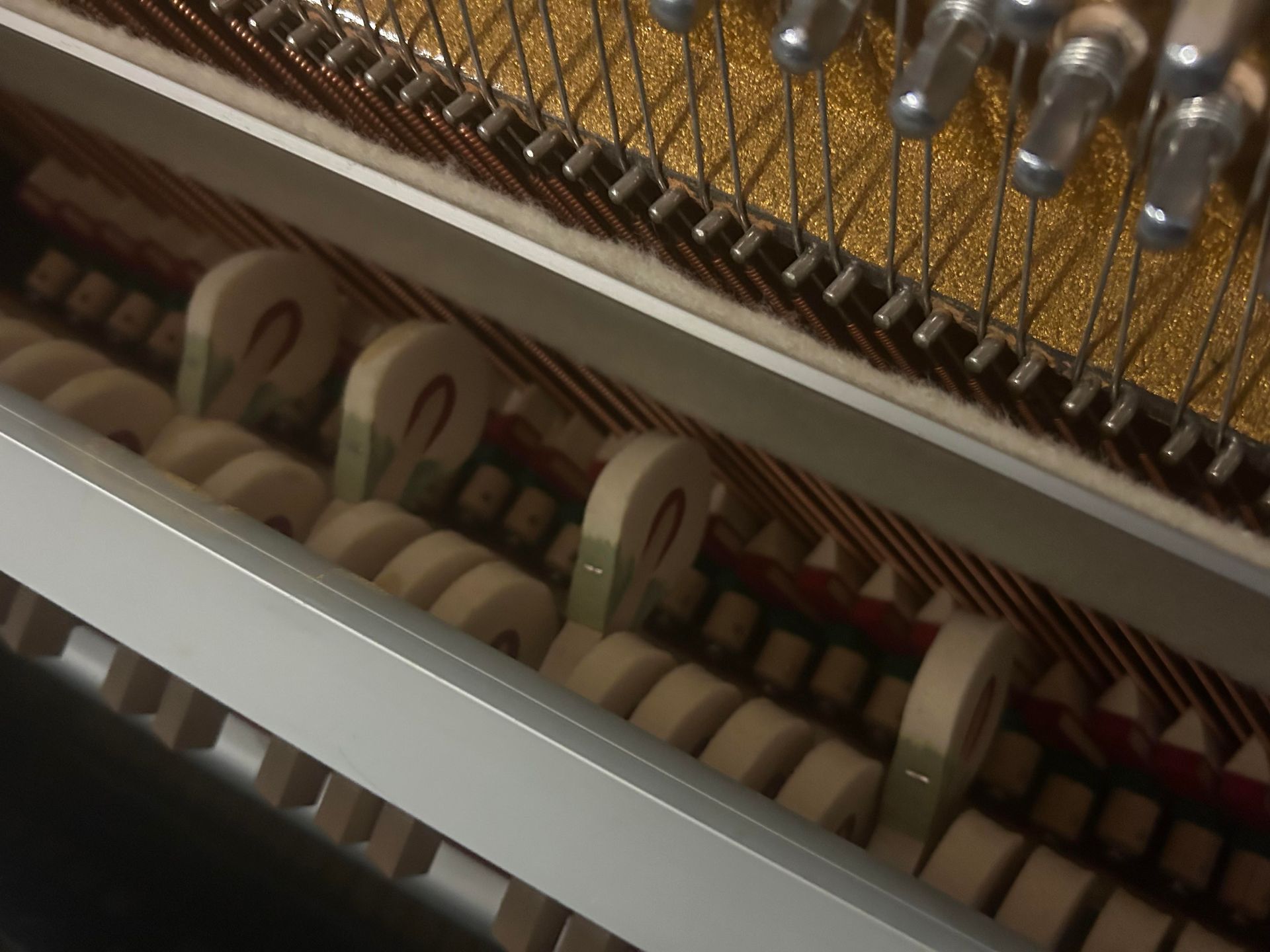 A close up of the inside of an upright piano