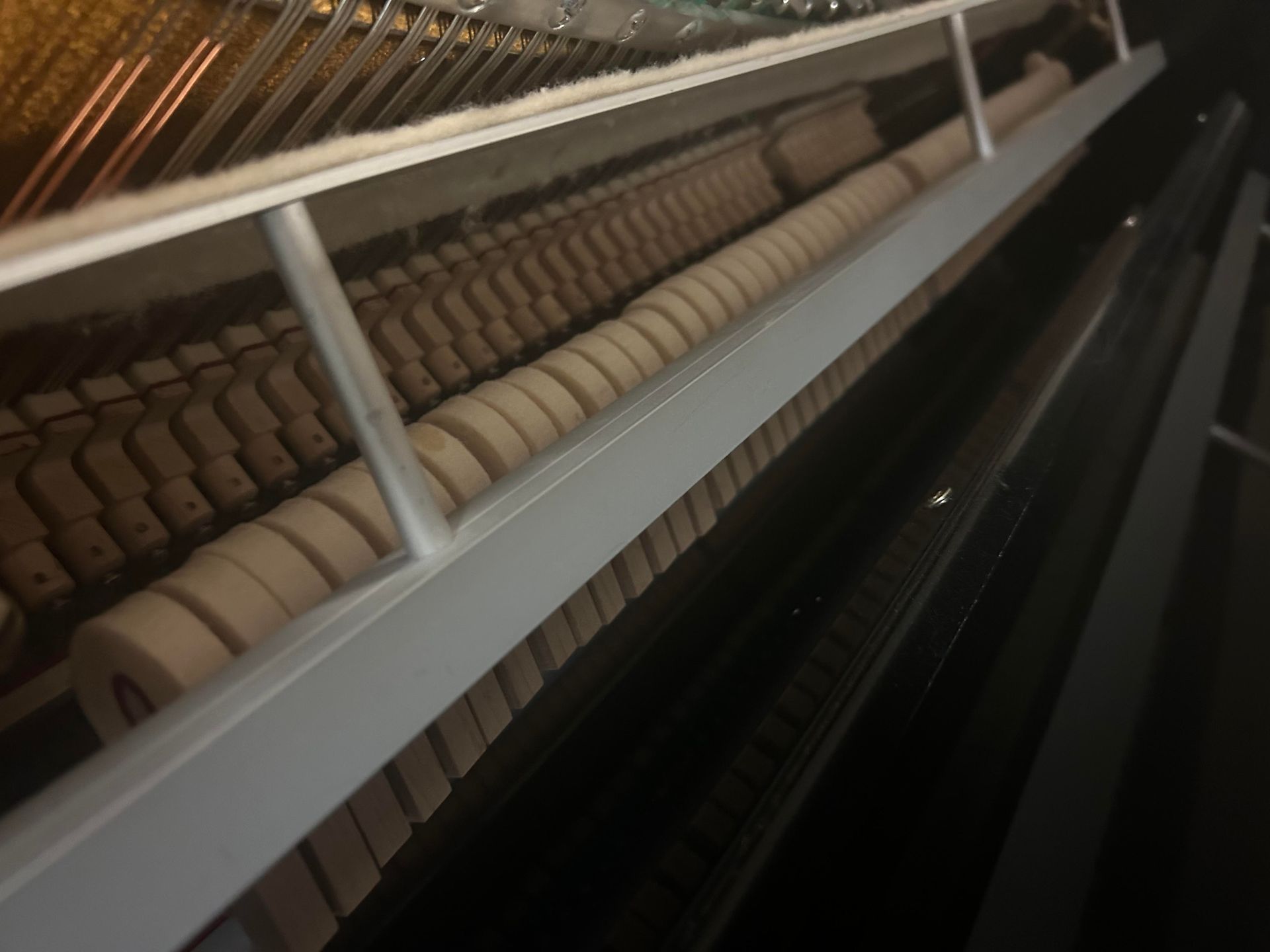A close up of the inside of a piano keyboard