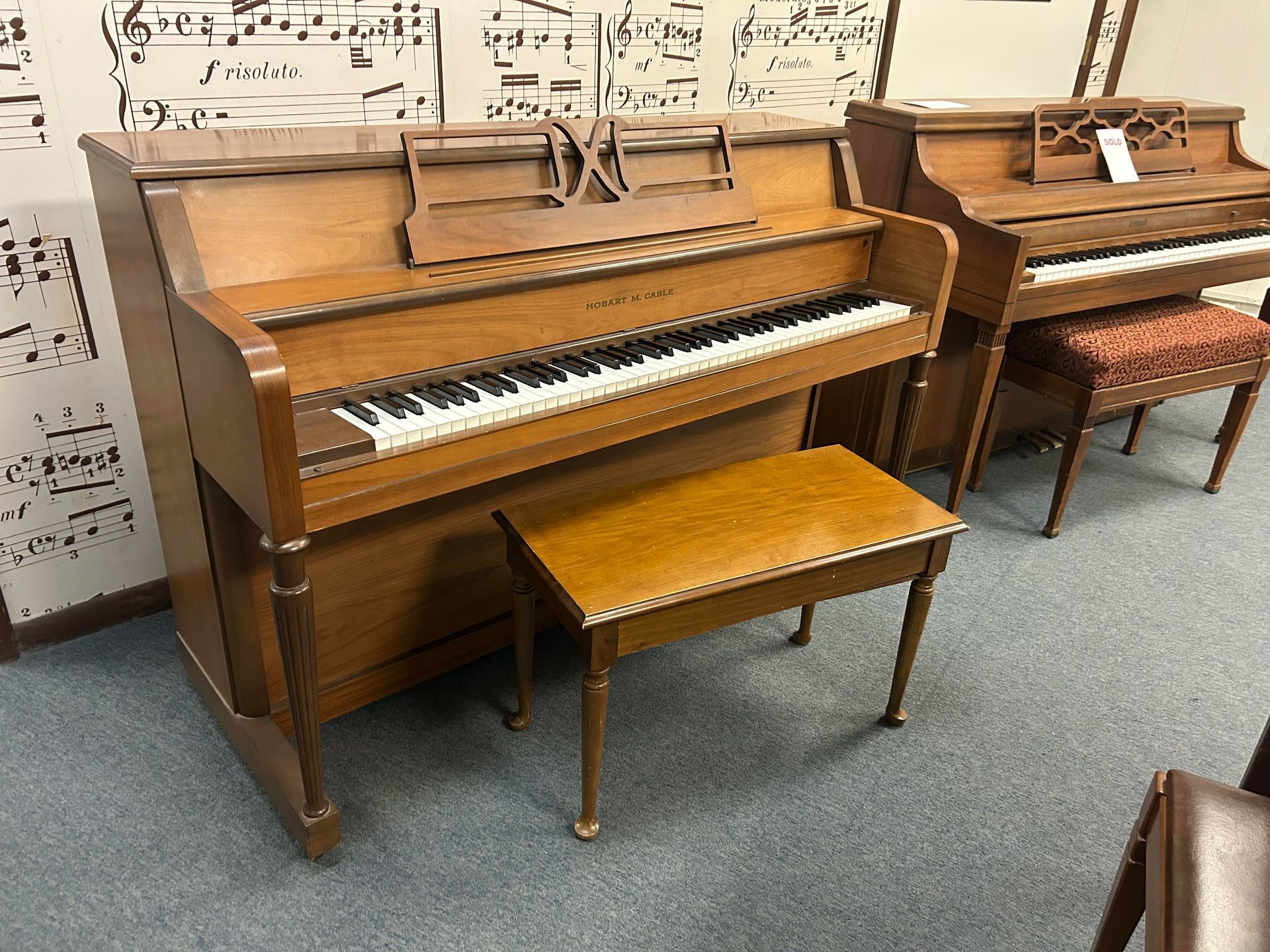 Two pianos are sitting next to each other in a room.