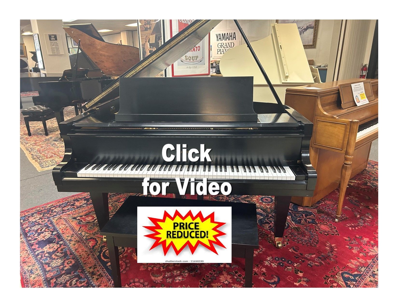 A black grand piano with music stand and bench in a showroom, with a 