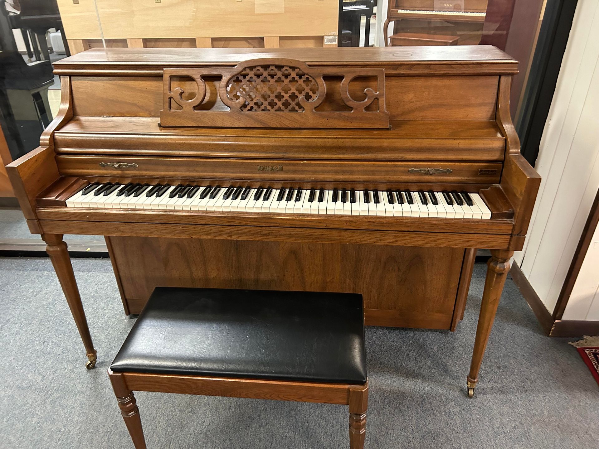 A piano with a bench next to it in a room.