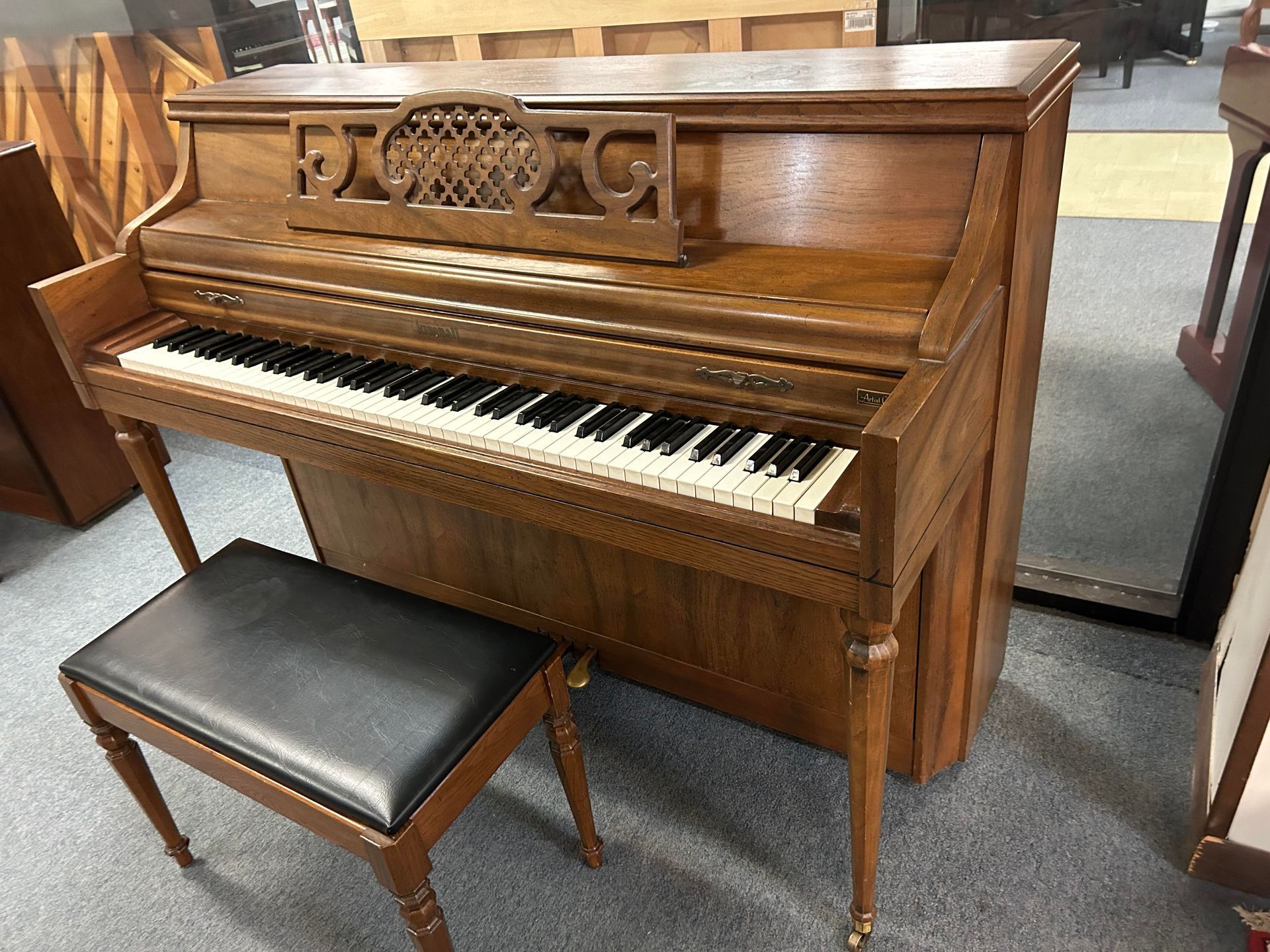 A piano with a bench next to it in a room.