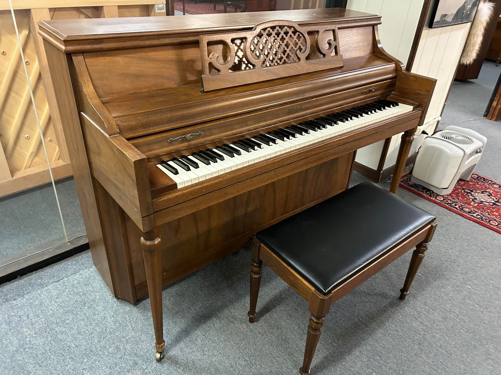 A piano with a bench next to it in a room.