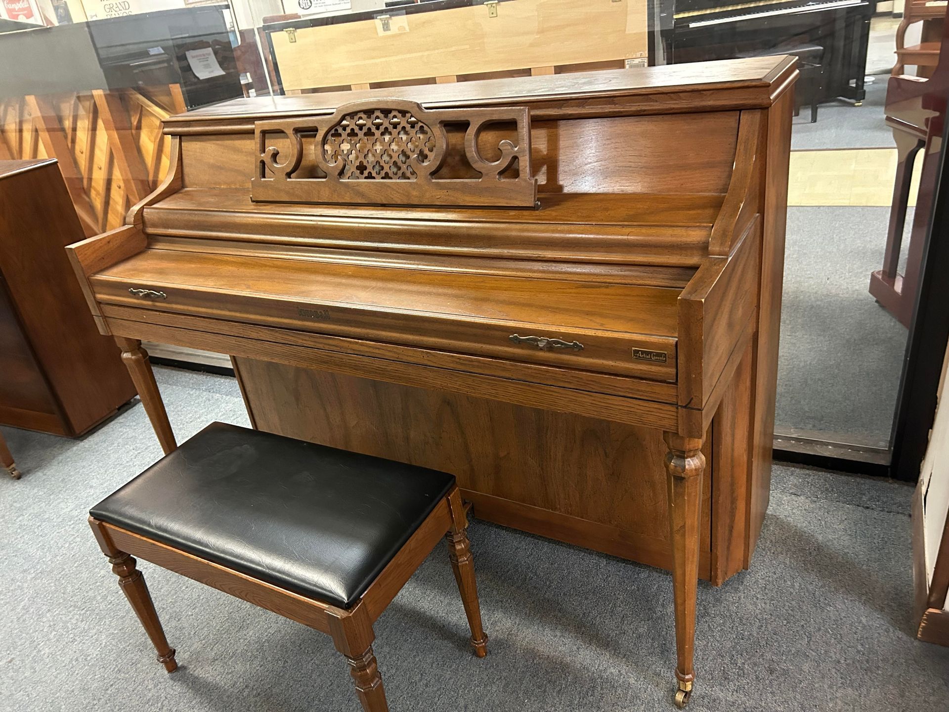 A piano with a bench next to it in a room.