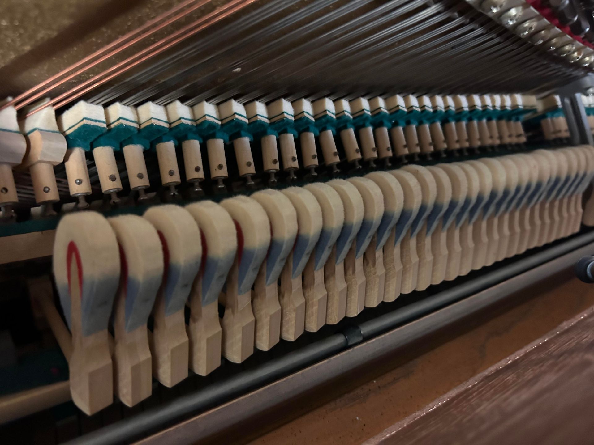A close up of the inside of a piano showing the hammers