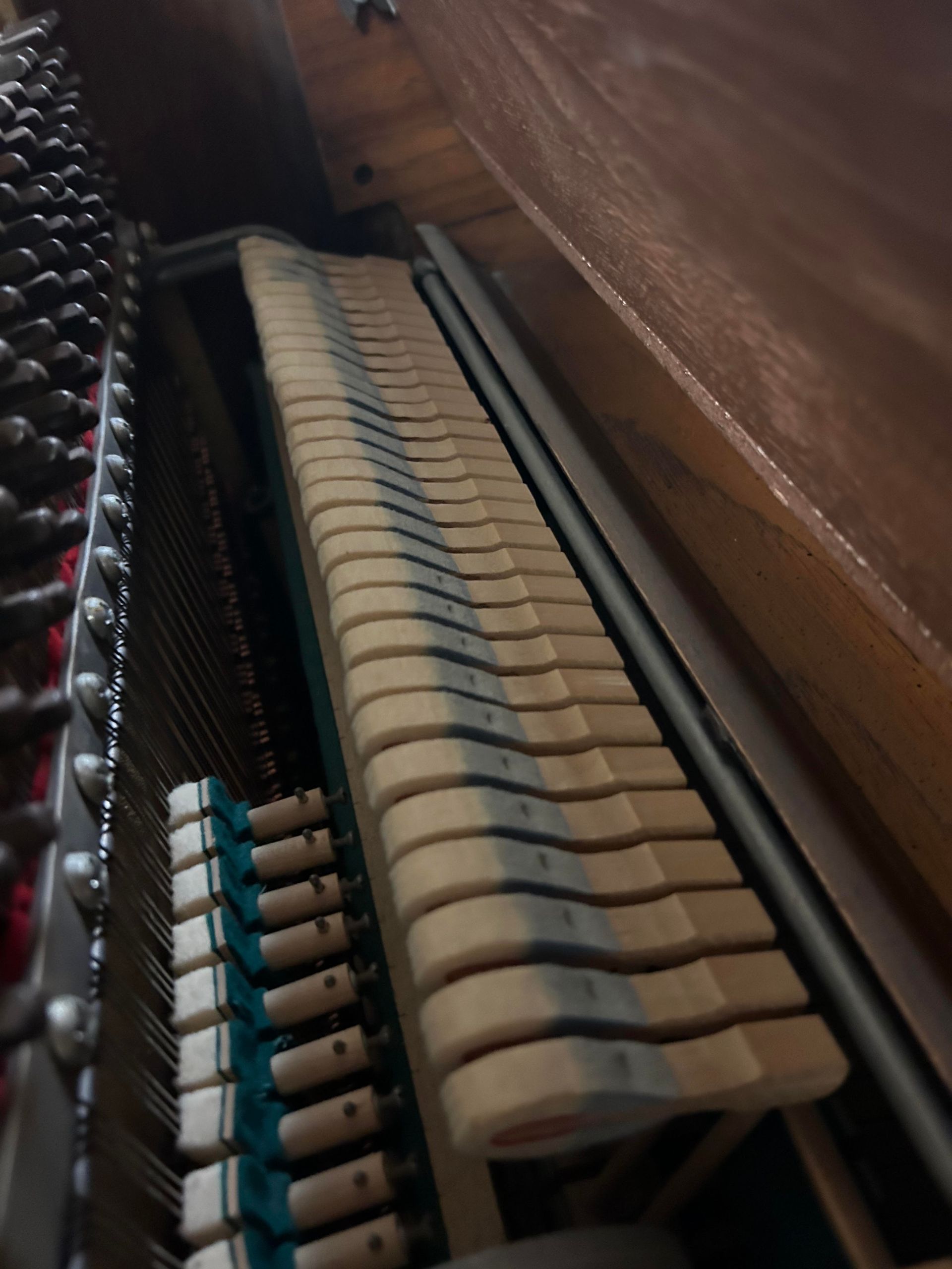 A close up of the inside of an upright piano