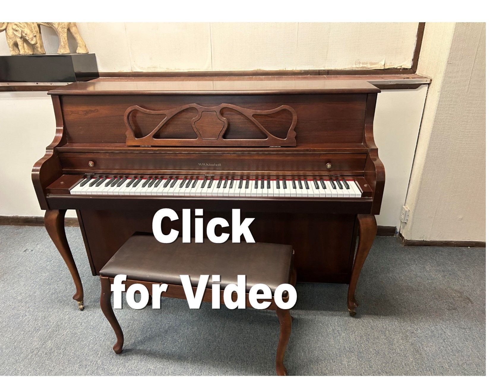 A piano with the words click for video below it