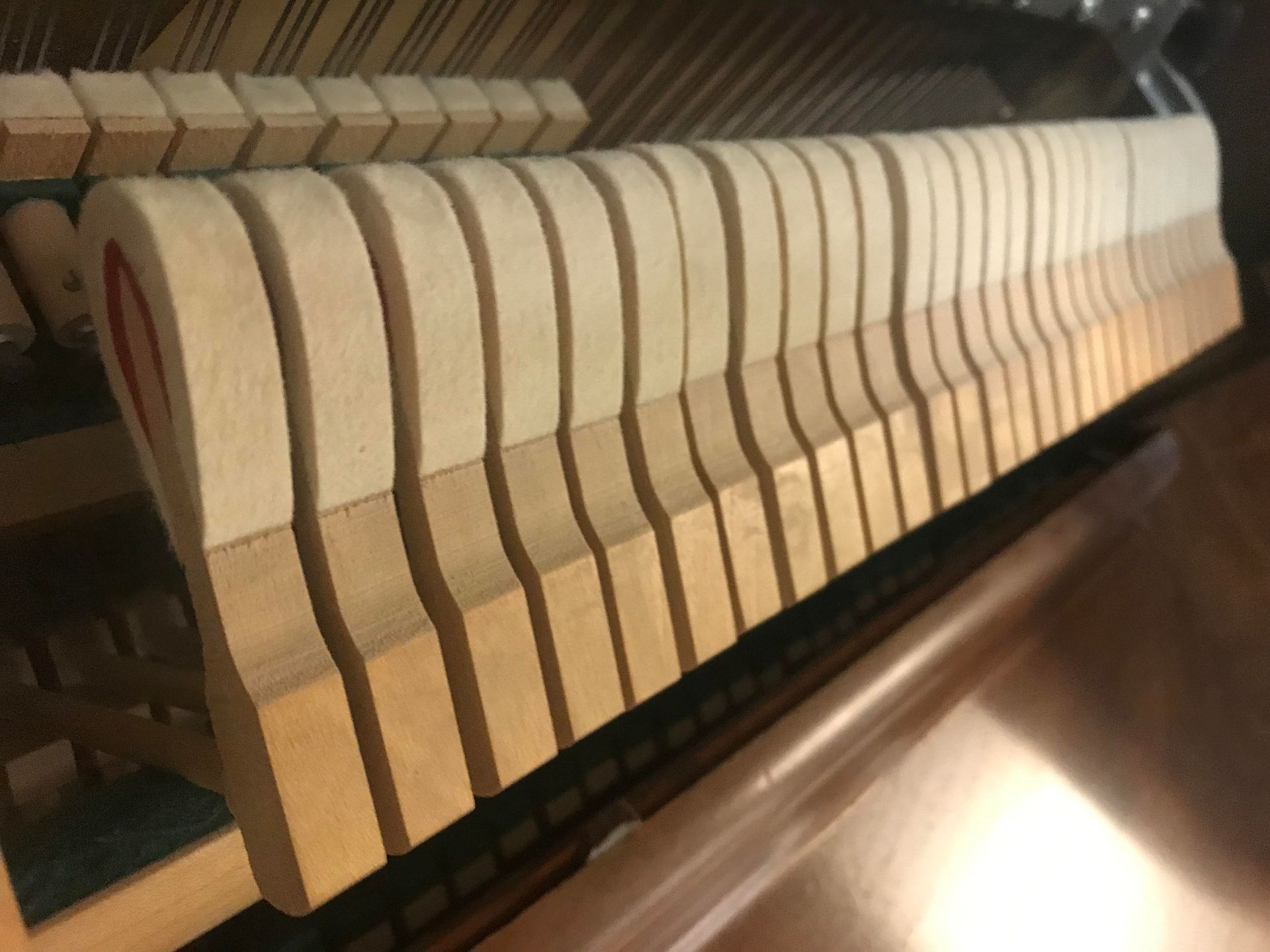 A close up of a piano hammer with a red heart on it