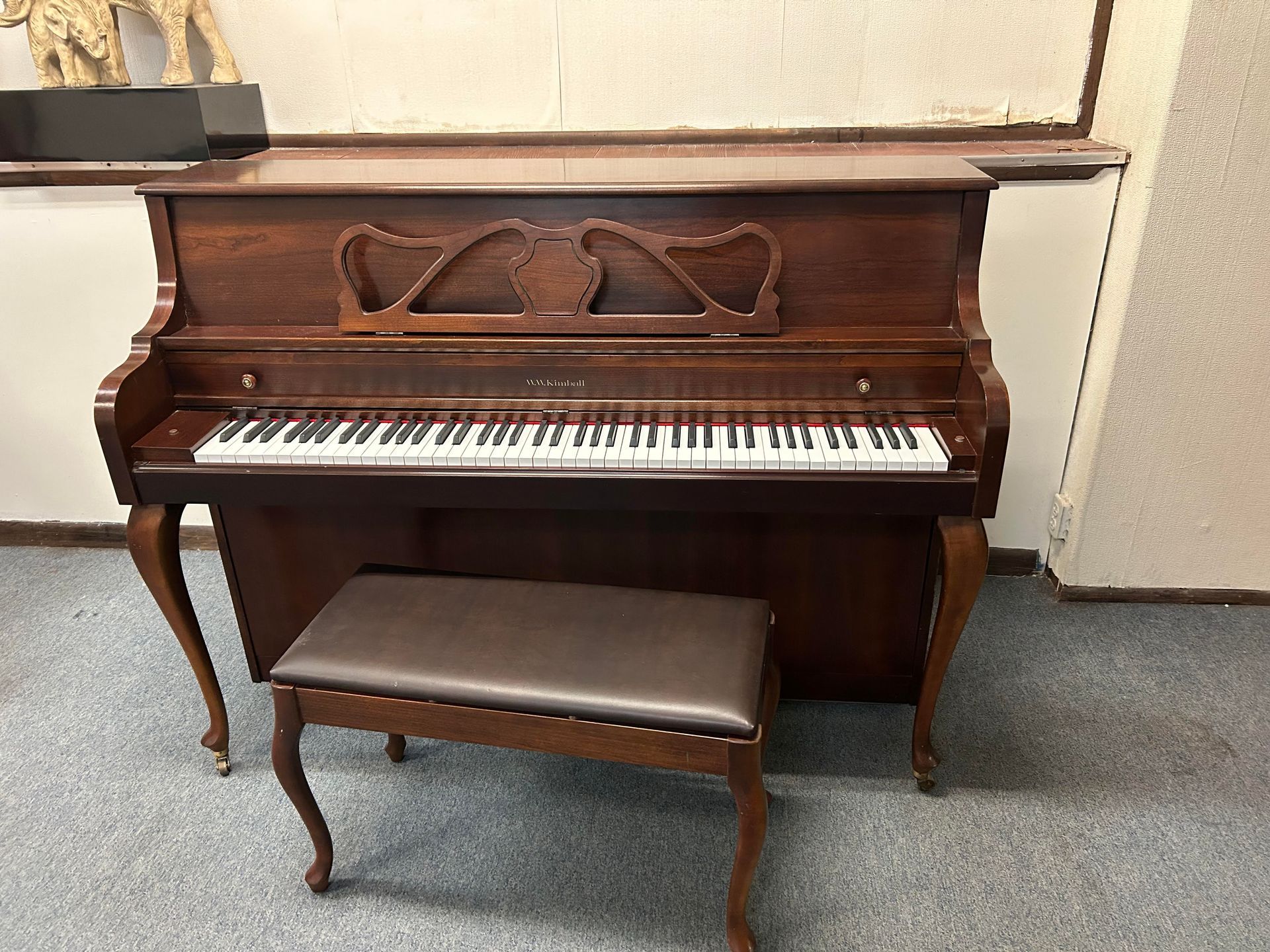 A piano with a bench next to it in a room.