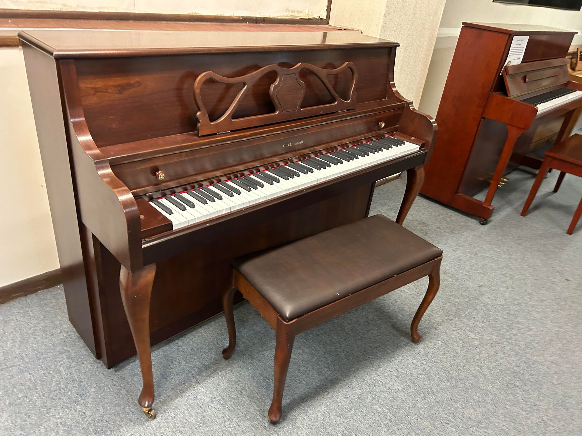 A piano with a bench next to it in a room.