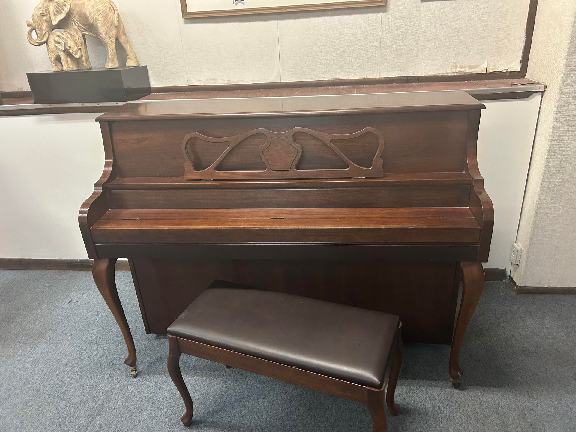 A piano with a bench next to it in a room