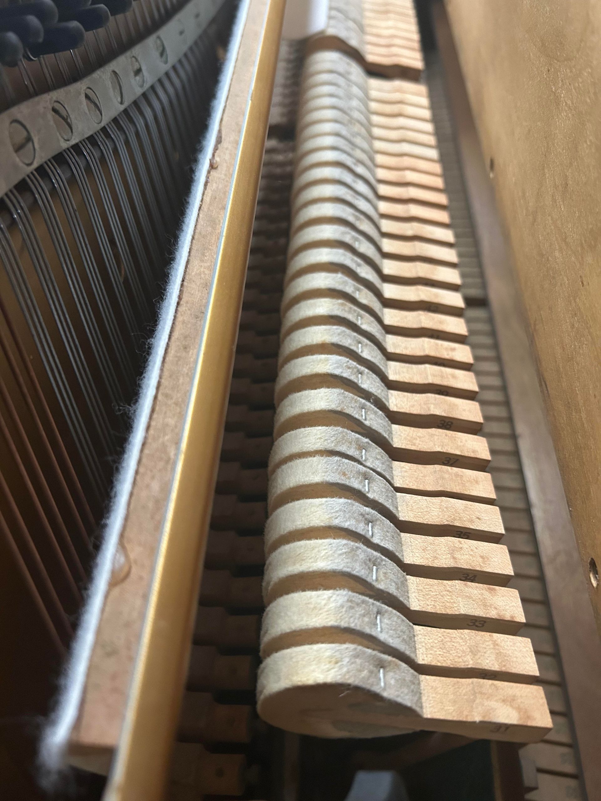A close up of the inside of an upright piano