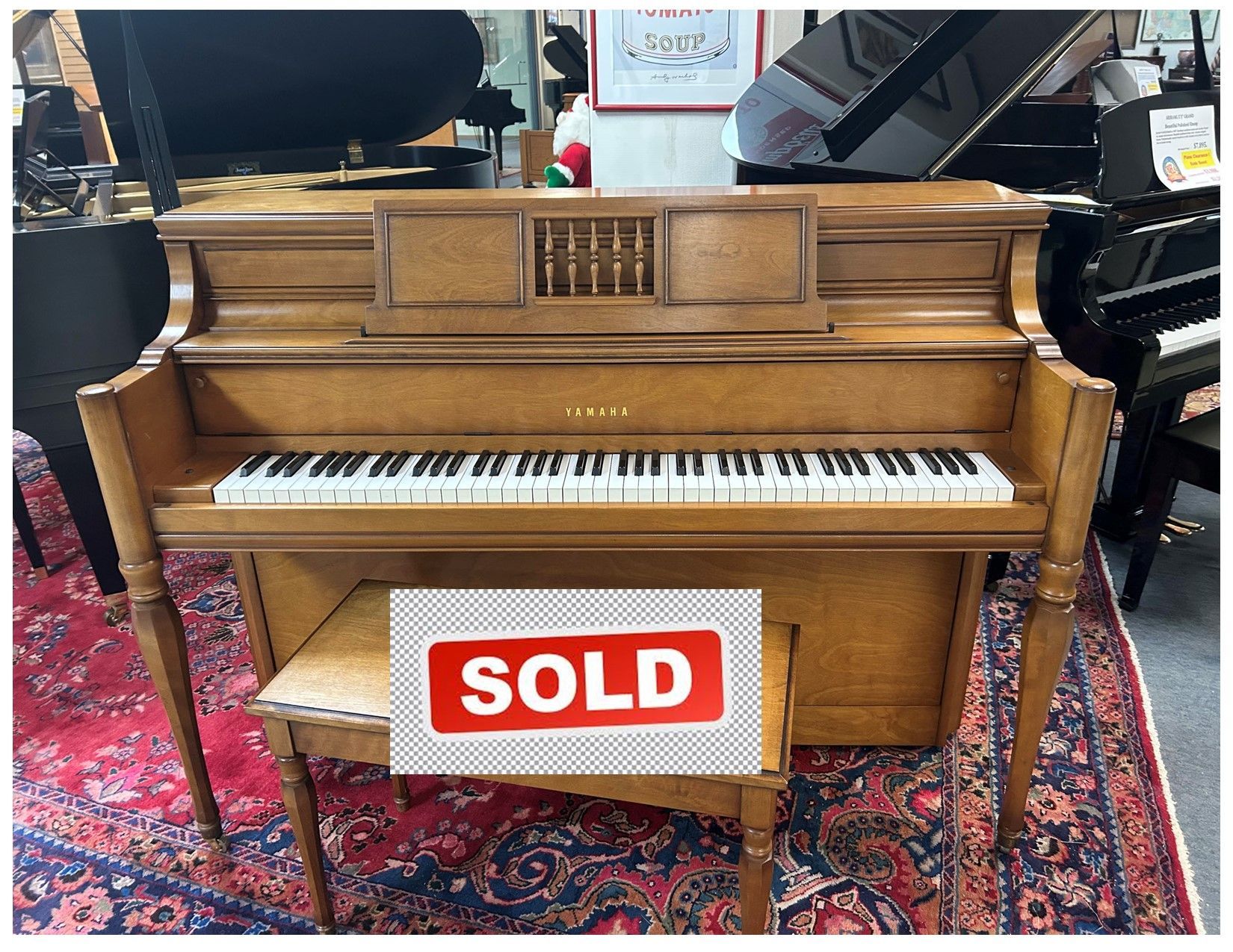 A piano is sitting on a rug with the words click for video below it.