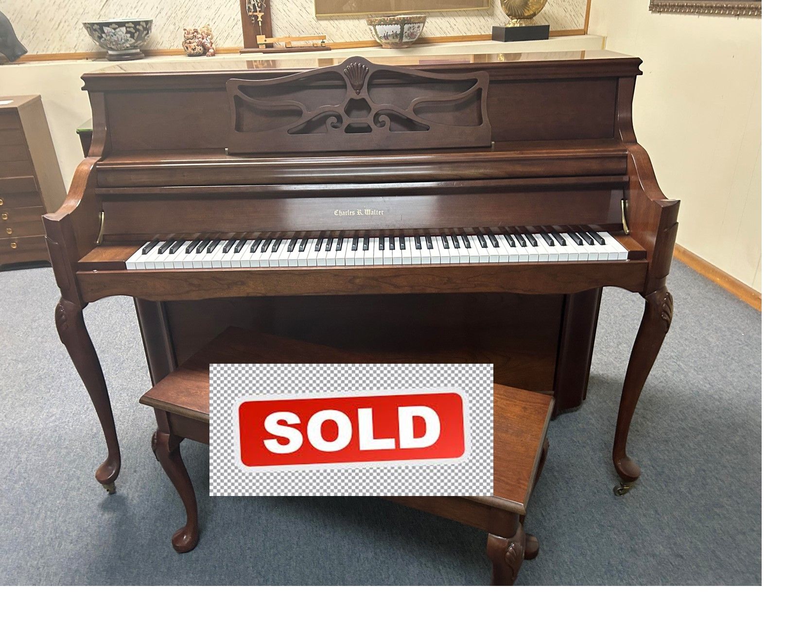 Upright piano with bench, wood finish.