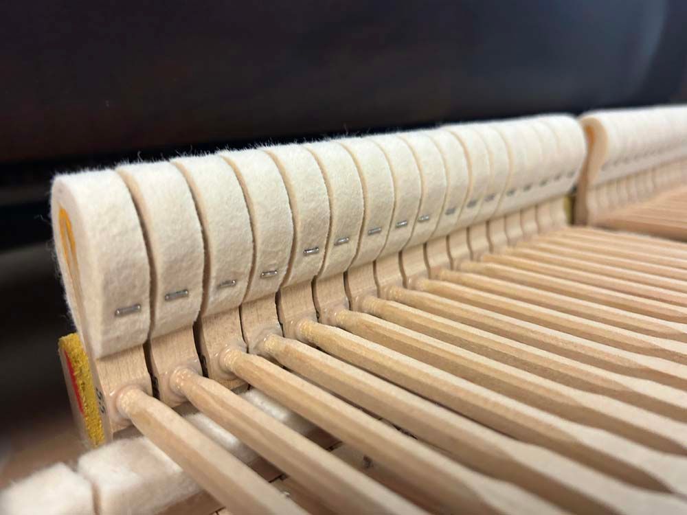 A close up of a piano 's hammers and keys.