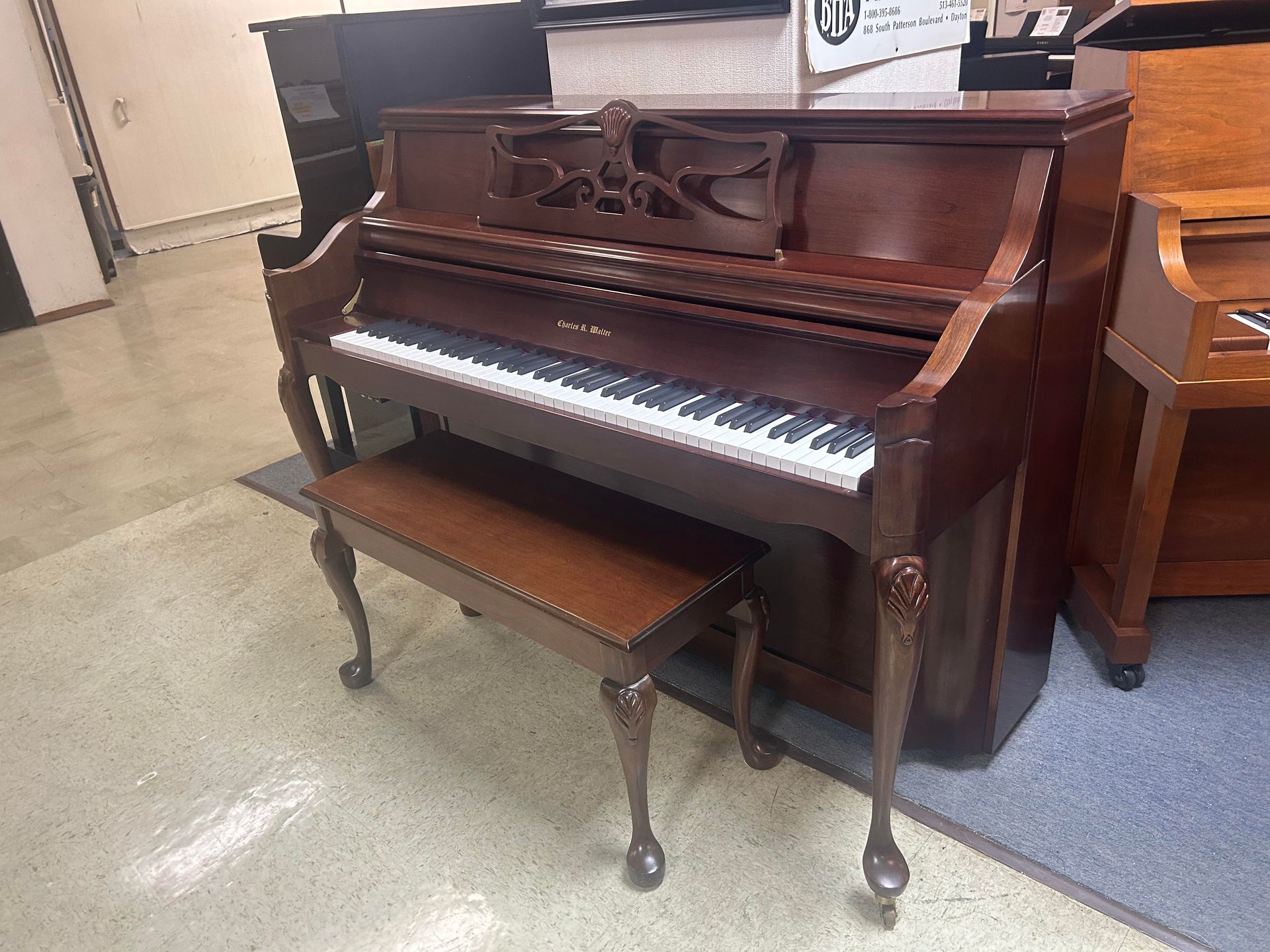 Brown upright piano with matching bench.