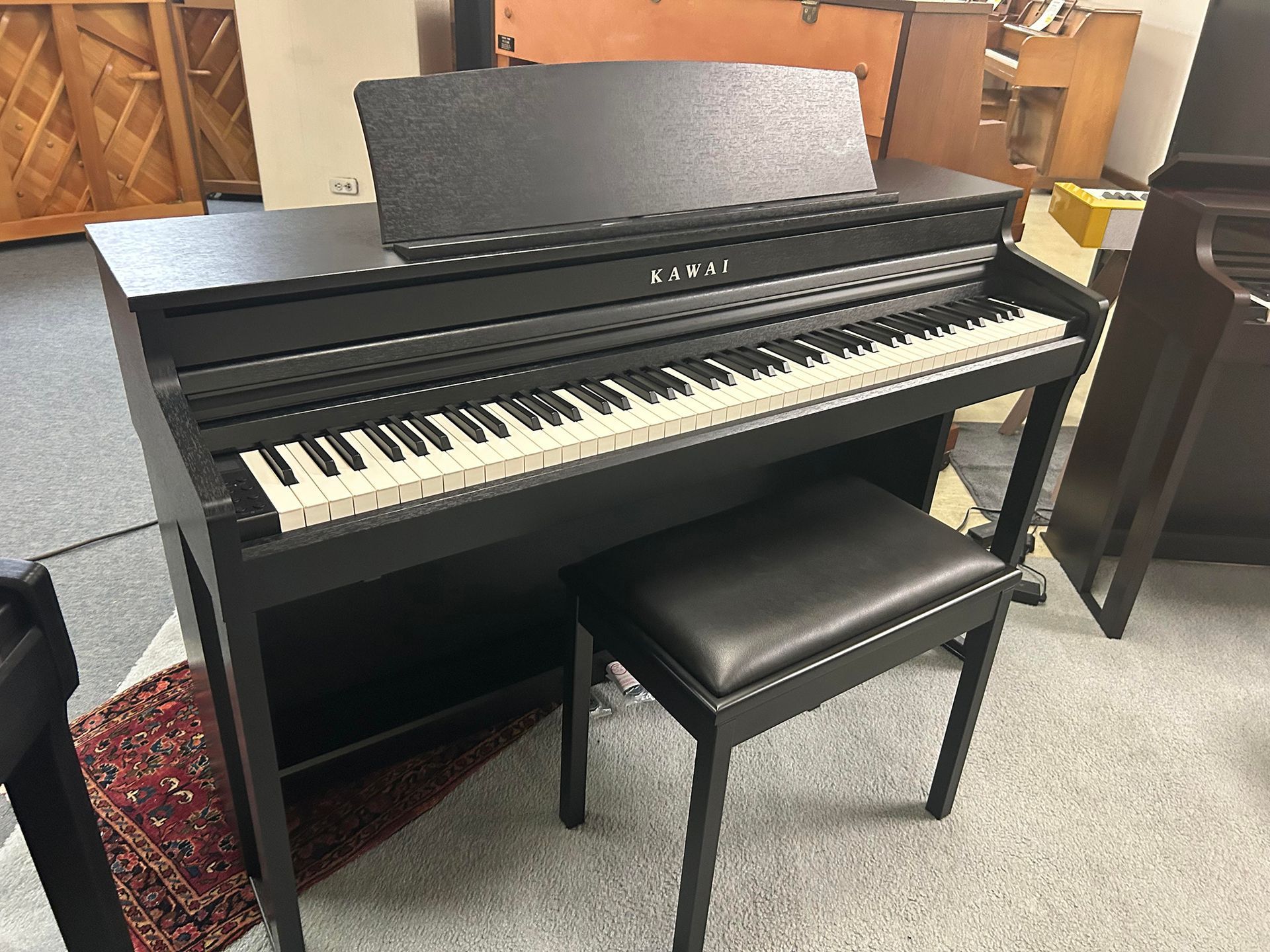 Black digital piano with matching bench.