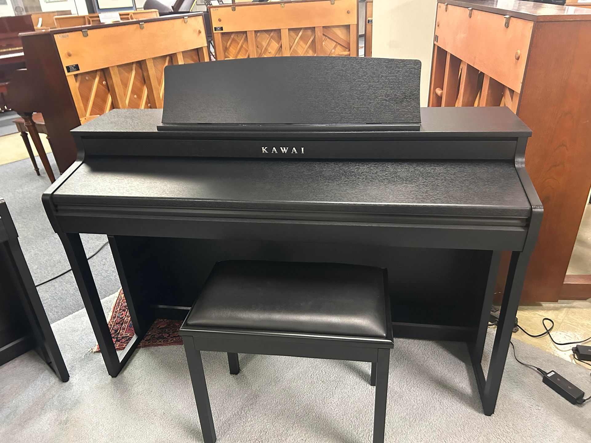 Black Kawai digital piano with bench.